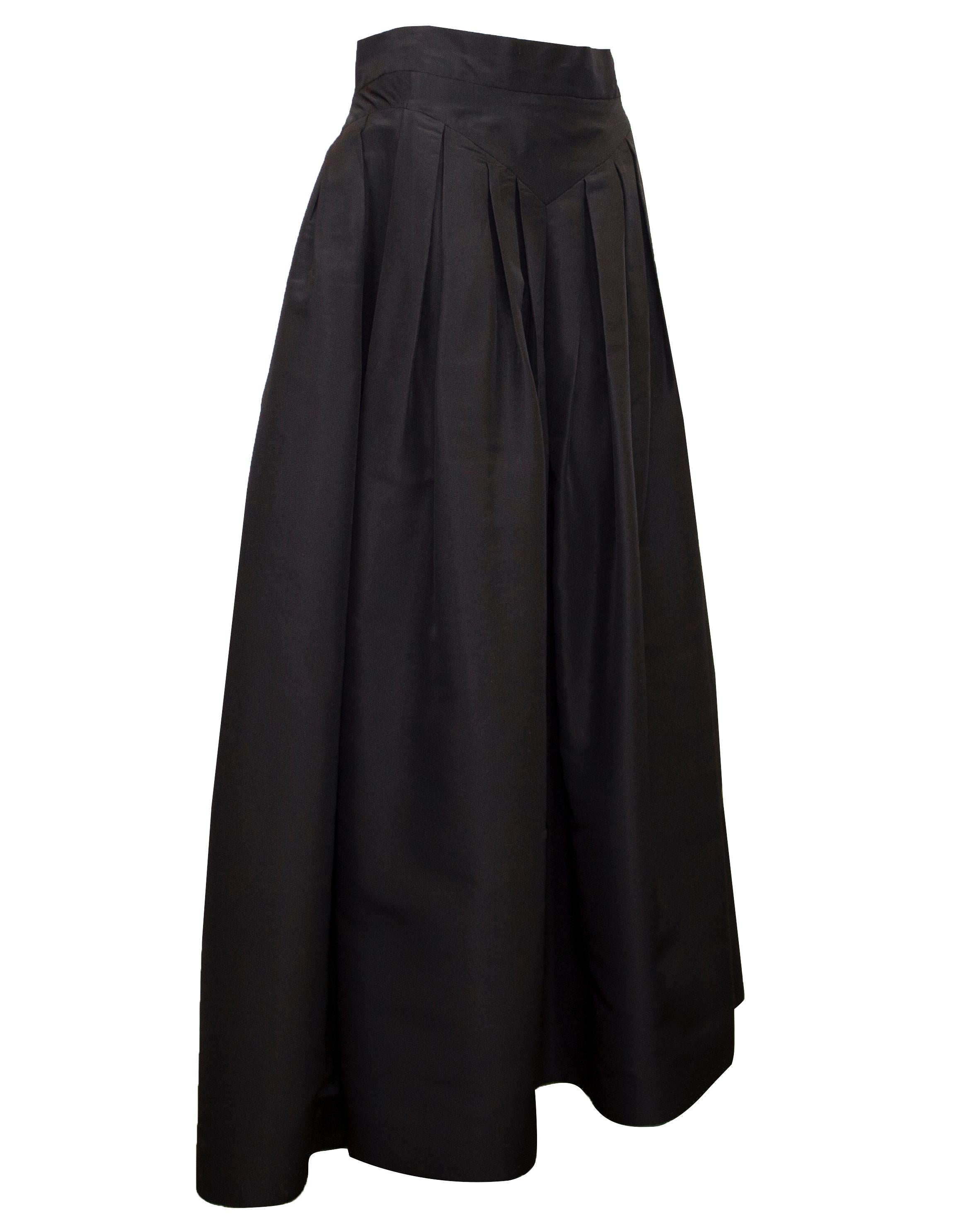 Classic and timeless Chanel black silk taffeta floor length ball skirt. Fitted through the waist with a v shaped drop waist yoke. Inverted pleats at the hip to add volume to the a line shape. Fastens with a centre back detailed camellia flower gold