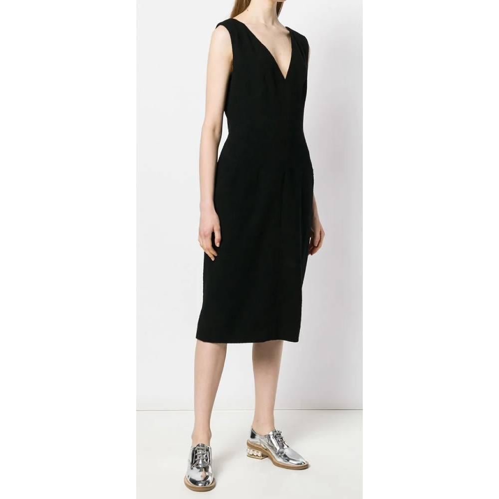 Chanel black dress in wool blend. Model with straps, wide V-neck front and square on the back. Front web pockets. Back zip and hook closure. Midi length.

Years: 2000s 

Made in Italy 

Size: 42 FR 

Flat measurements 
Height: 112 cm 
Bust: 45