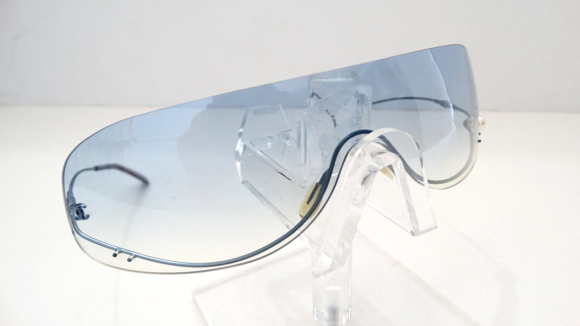 Die entzückendsten Chanel-Sonnenbrillen sind da! Diese randlosen Schild-Sonnenbrillen aus dem Lagerbestand von Chanel aus den 1990er Jahren verfügen über klare:: hellblau getönte Gläser mit einem subtilen Ombre-Effekt. Die leichten blauen Drahtbügel