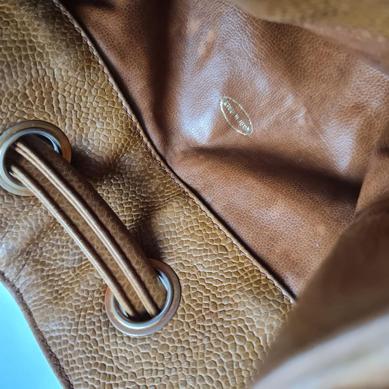 Vintage drawstring hobo bag from the 90s in brown caviar leather. Item is in fair condition. Visible tiny pen mark on the exterior leather. Leather has slightly discolored. Visible water marks on the lining. Holo still intact, series #2. Comes as it