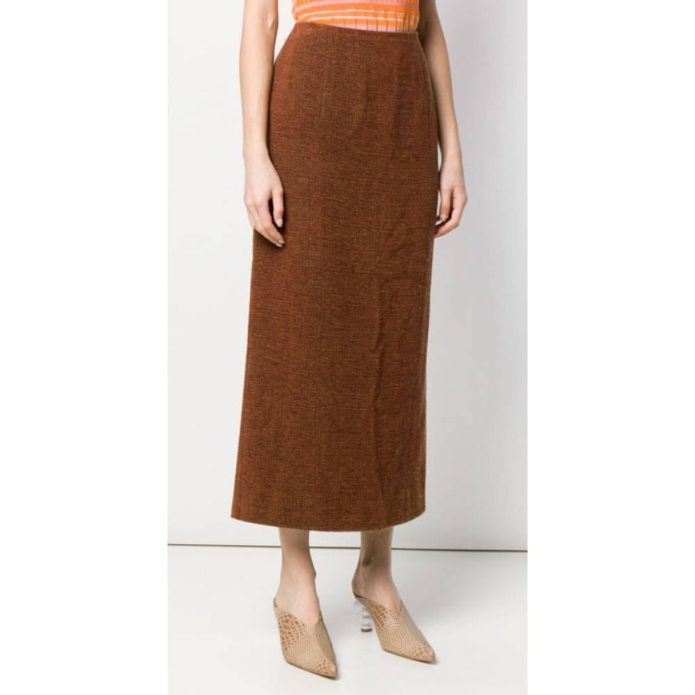 Chanel classy style is perfeclty combined with contemporary streetwear in this orange-brown high-waist midi skirt. Straight cut, invisible back zip fastening and rear central vent with logoed buttons.

Year: 1998

Made in France

Size: 42 FR

Linear