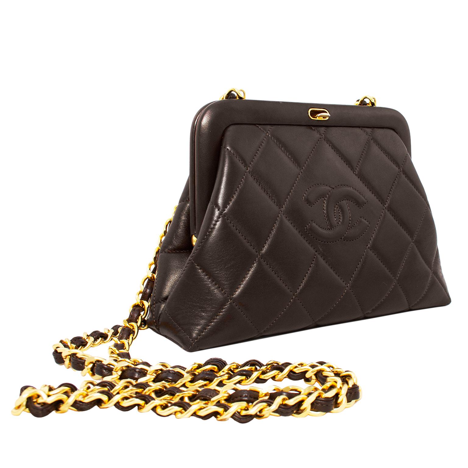 Incredibly stunning Chanel frame style bag from the 1980s. Deep chocolate brown quilted supple leather with contrasting warm gold hardware. Push down on the snap closure tab to open the frame and reveal the iconic maroon leather interior that all