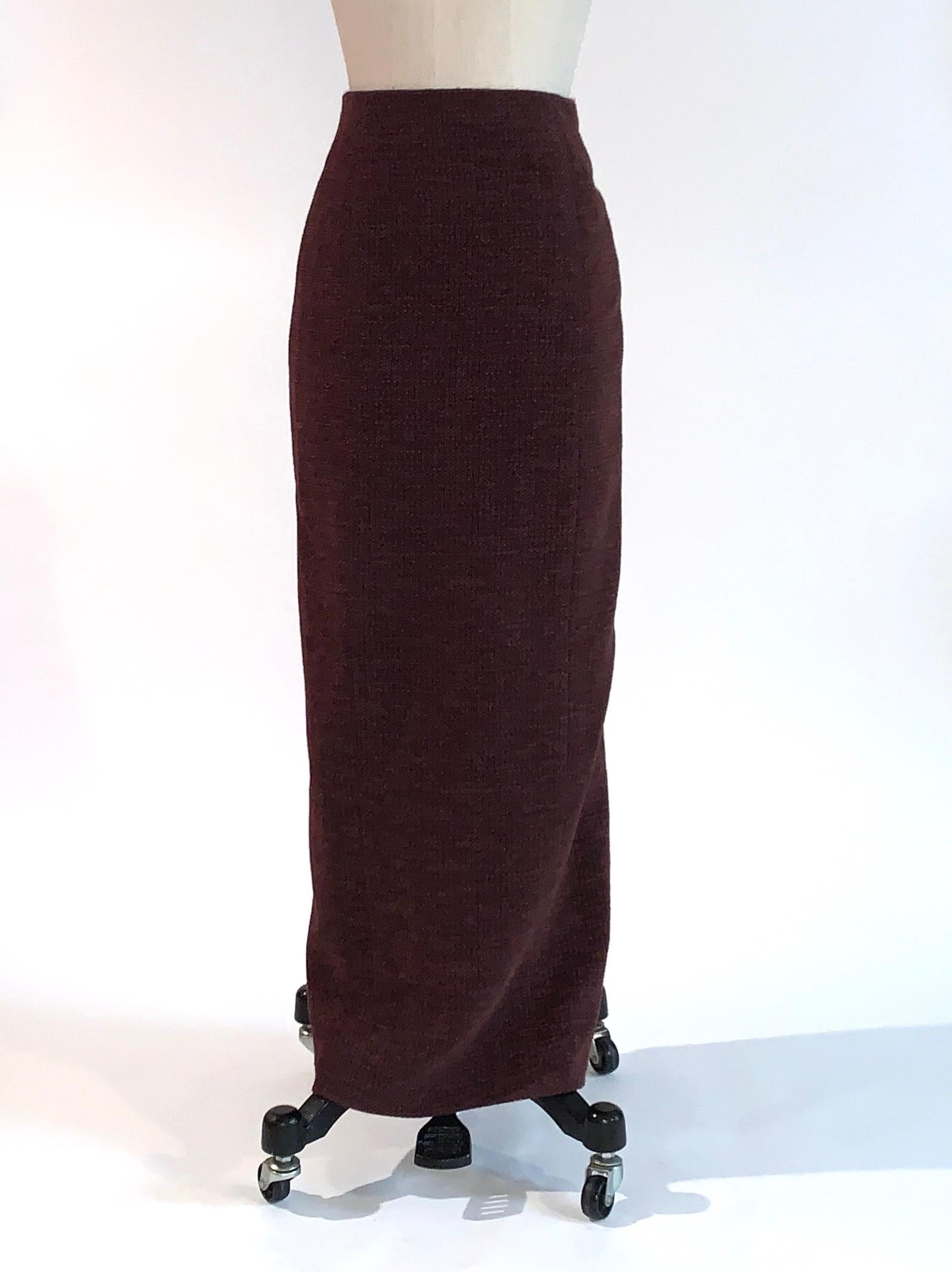 Chanel vintage burgundy tweed long skirt, circa 1998. (Fits as midi skirt if taller, maxi if not.) Tweed has navy blue and red accents, lending the skirt an overall slightly purple effect. Four bronze tone metal CC logo buttons at back slit. Back