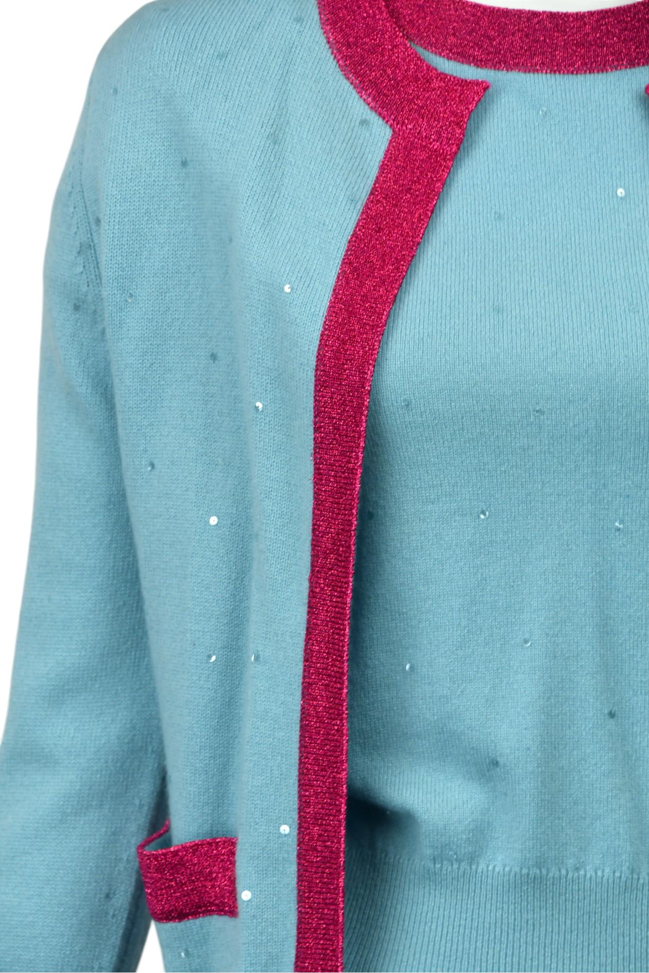 Cet ensemble de jumeaux Chanel dégage une élégance enjouée avec son mélange de cachemire bleu ciel orné de paillettes délicates, contrastées par de riches bordures métalliques fuchsia. L'ensemble se compose d'un pull à manches courtes et d'un