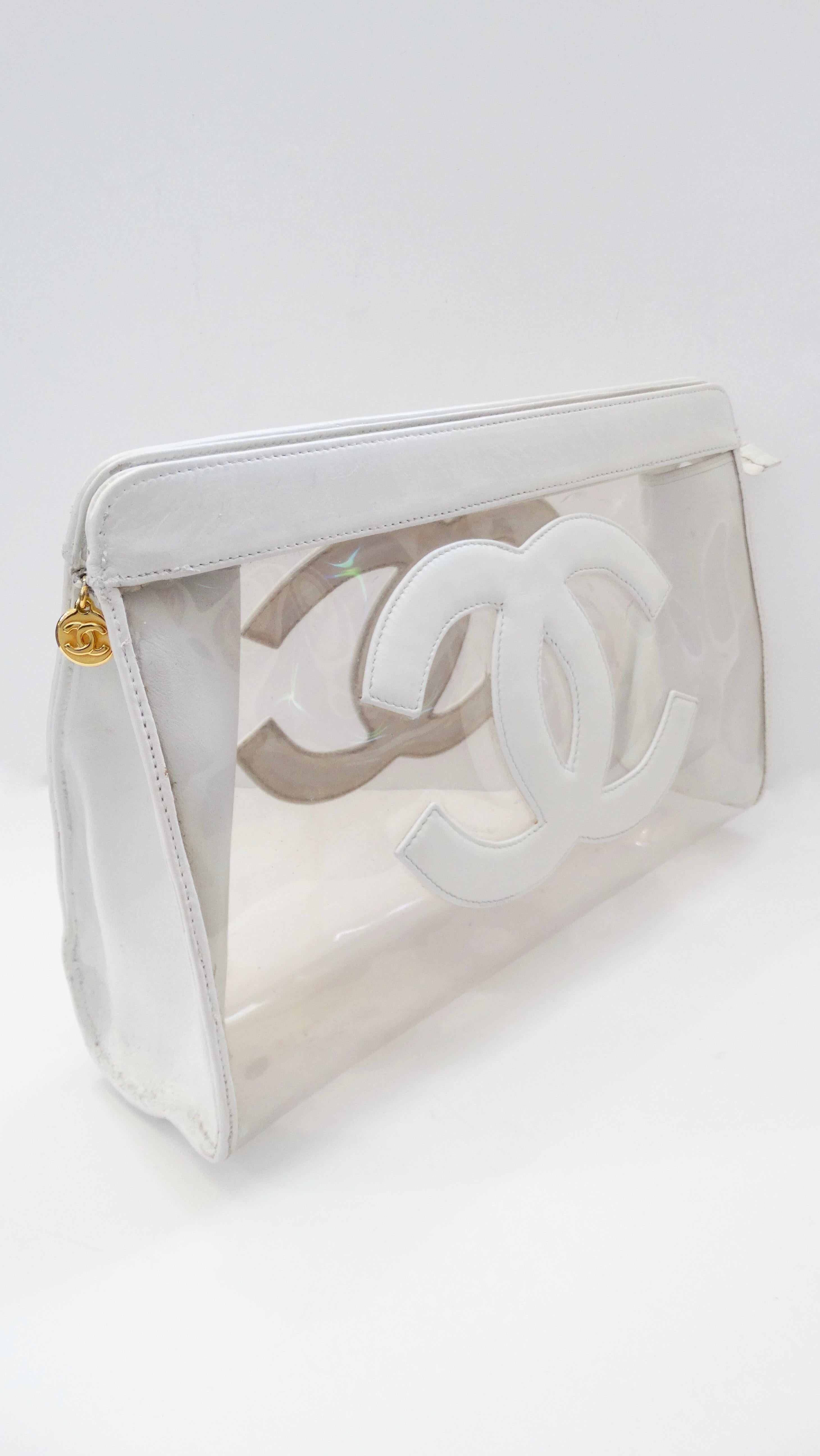 You can't go wrong with a great Chanel clutch! Circa 1990s, this clear PVC clutch features a white leather trim and the iconic Chanel CC on the front and back face. Includes a tonal white top zipper with a gold plated CC embossed charm. The perfect