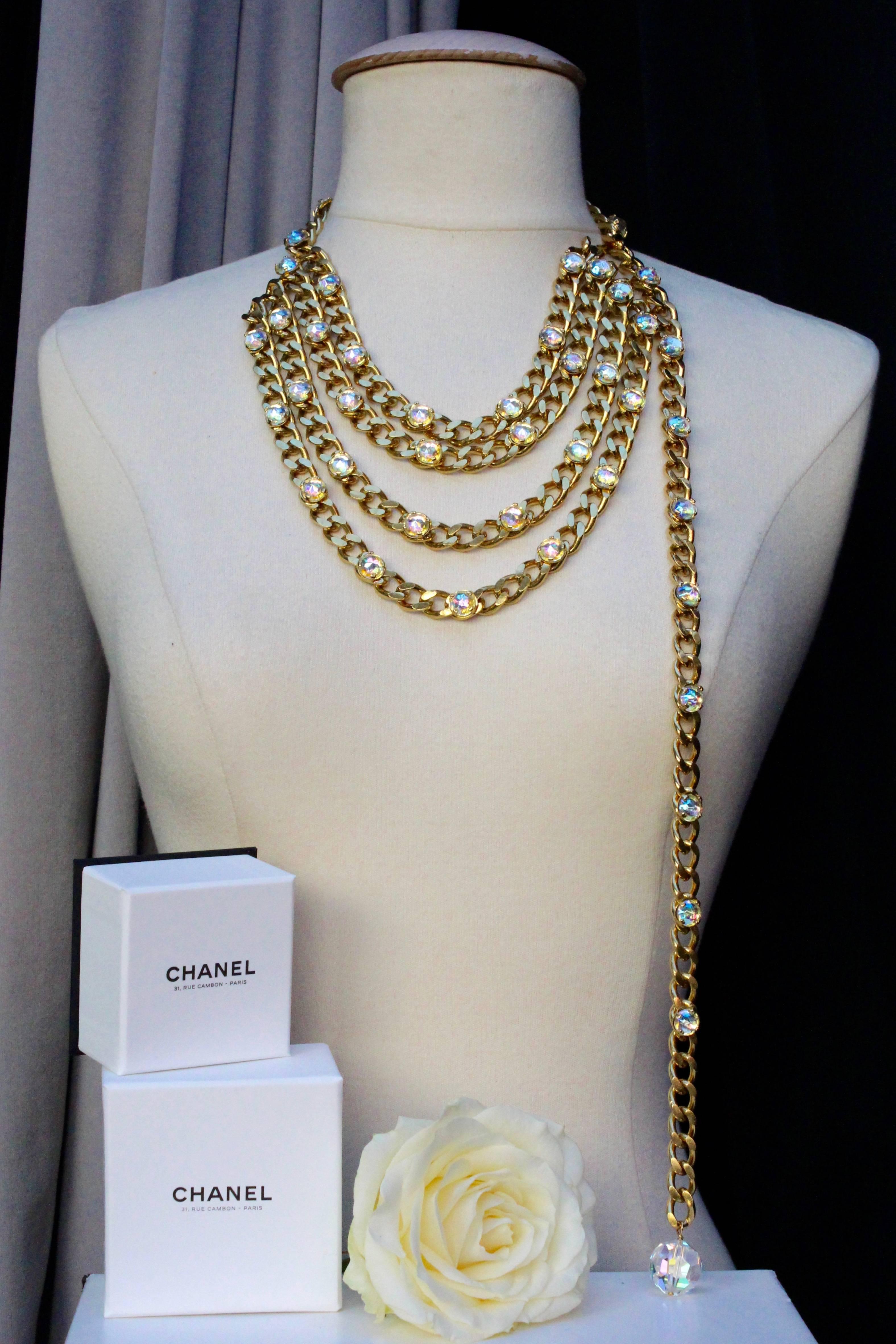 CHANEL (Made in France) Stunning gilded metal belt composed of a wide curb chain decorated with large Swarovski crystals. It features a front drapé made of four strands of chain. It is finished with a large faceted crystal.

It can be worn as a belt