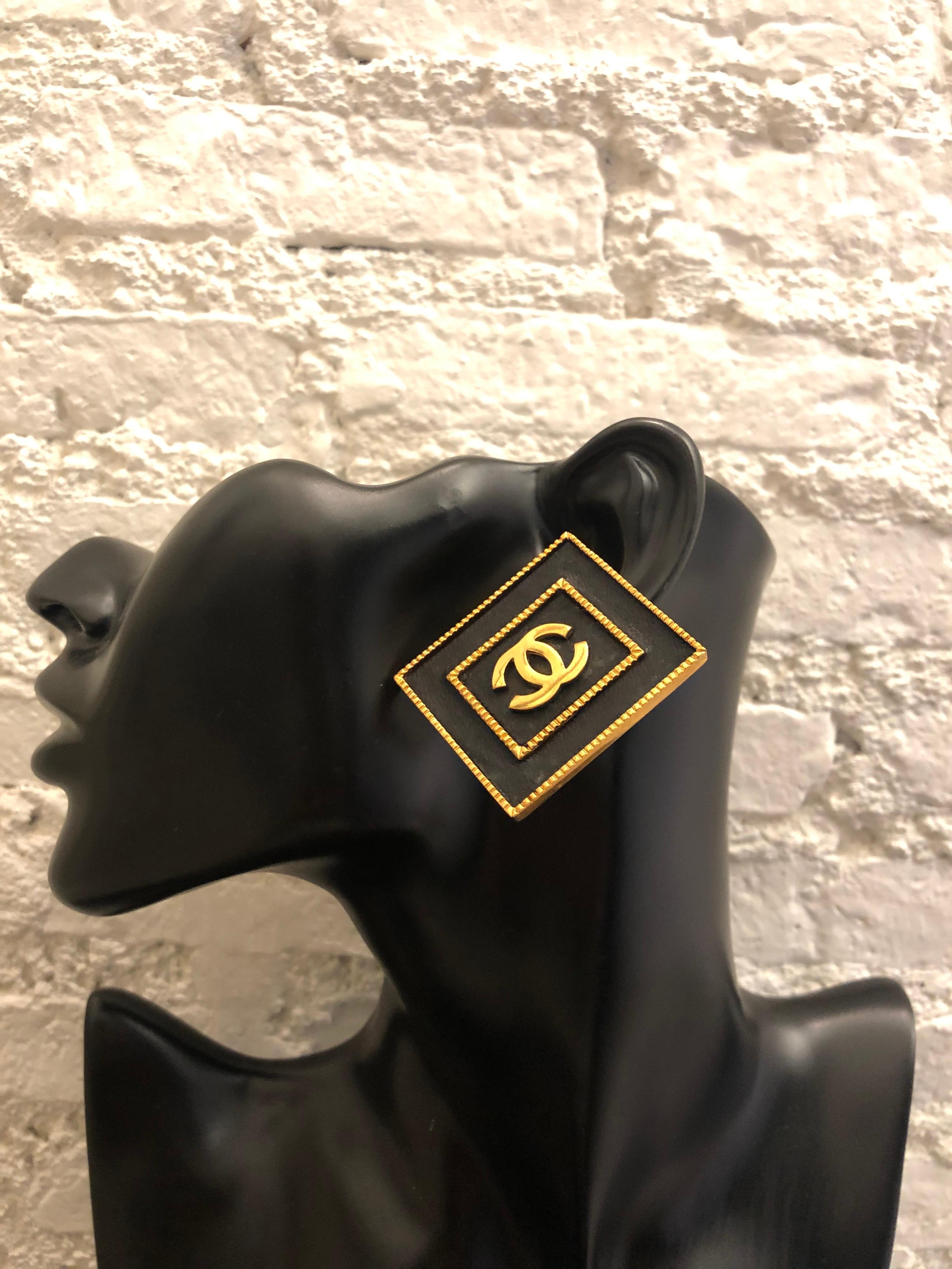 Seltene goldfarbene Ohrringe mit quadratischem Rahmen aus schwarzem Leder aus den frühen 1990er Jahren. Jumbo-Ohrringe im Clip-on-Stil. Gestempelt 28 made in France. Maße: 4 x 3,4 cm.

Condit - Geringe altersbedingte und normale
