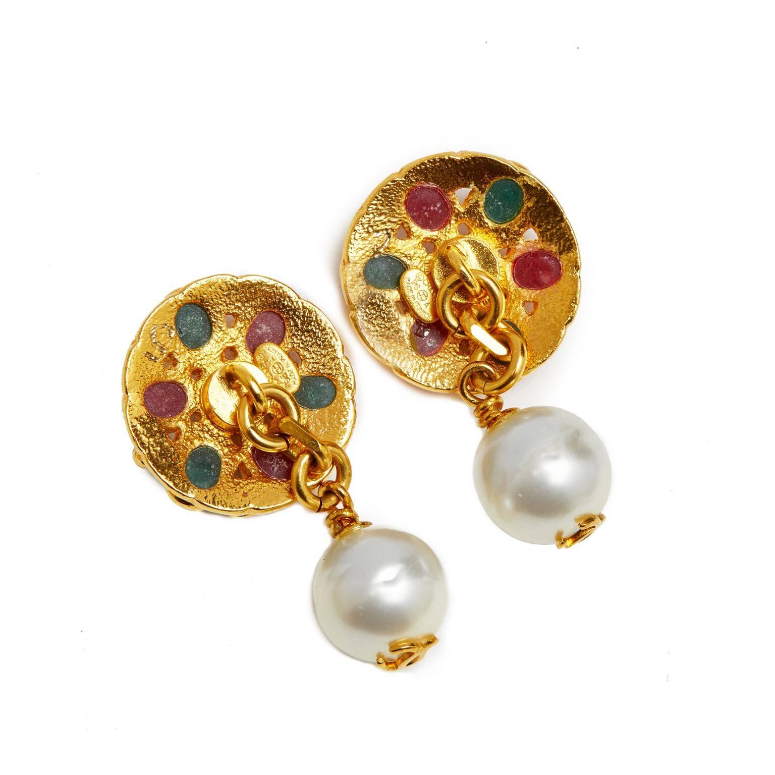 These exquisite and rare Maison Gripoix for Chanel cufflinks are in beautiful condition. Gold gilt disks decorated with poured glass cabochons in red, green and burgundy each linked to round pearlescent beads emblazoned with the iconic CC motif. The