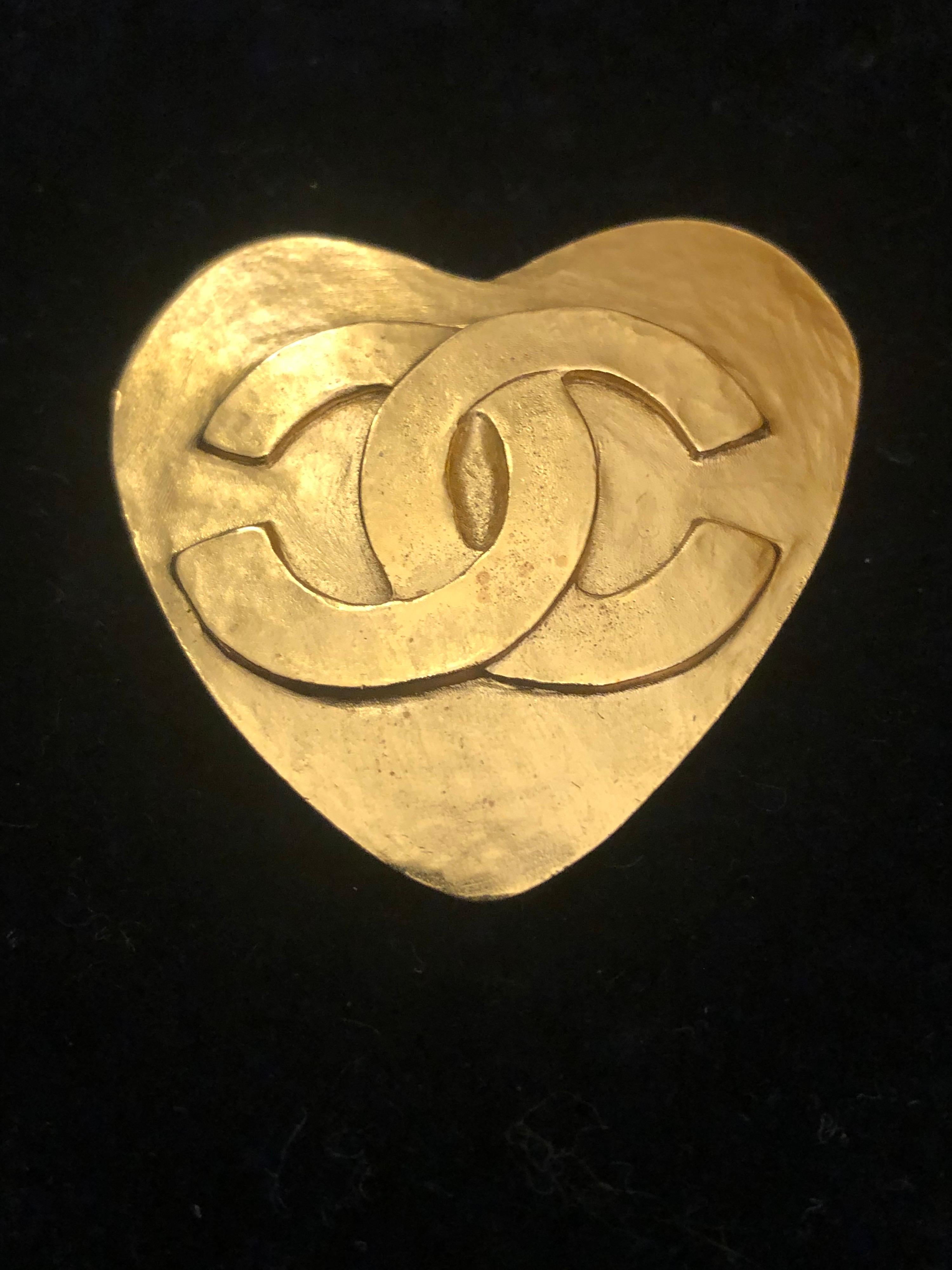 1990s Chanel gold toned brooch in heart shape featuring an oversized CC logo. Hook fastening. Stamped 95P made in France. Measures approximately 4.5 x 4.5 cm. Comes with box. 

Condition: Minor signs of wear. Generally in very good condition.