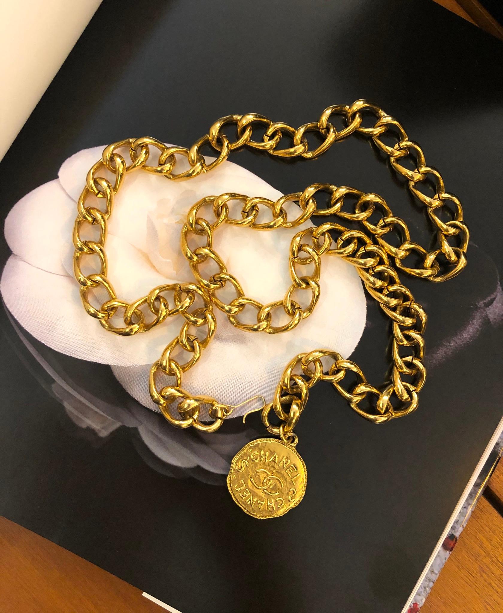 1990s Chanel gold toned chain belt featuring a gold toned Byzantine styled coin. It can be worn as a belt or a wrap around necklace. Stamped 98P made in France. Adjustable hook fastening. Length measures approximately 33” (84cm) Coin charm 1.25”