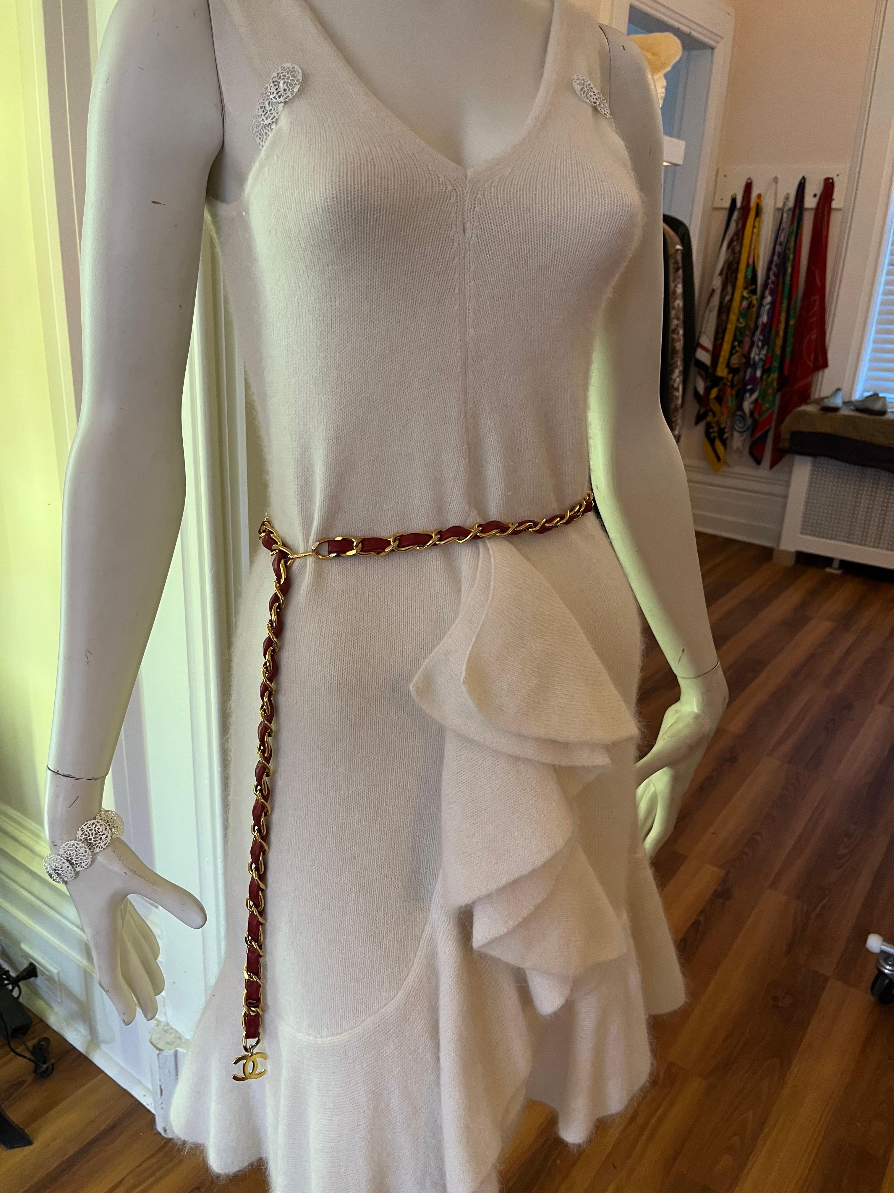 This gold-toned chain belt is interlaced with red leather and has a CC pendant and hook fastening. Chanel is stamped on the hook, and the length will fit up to a 36