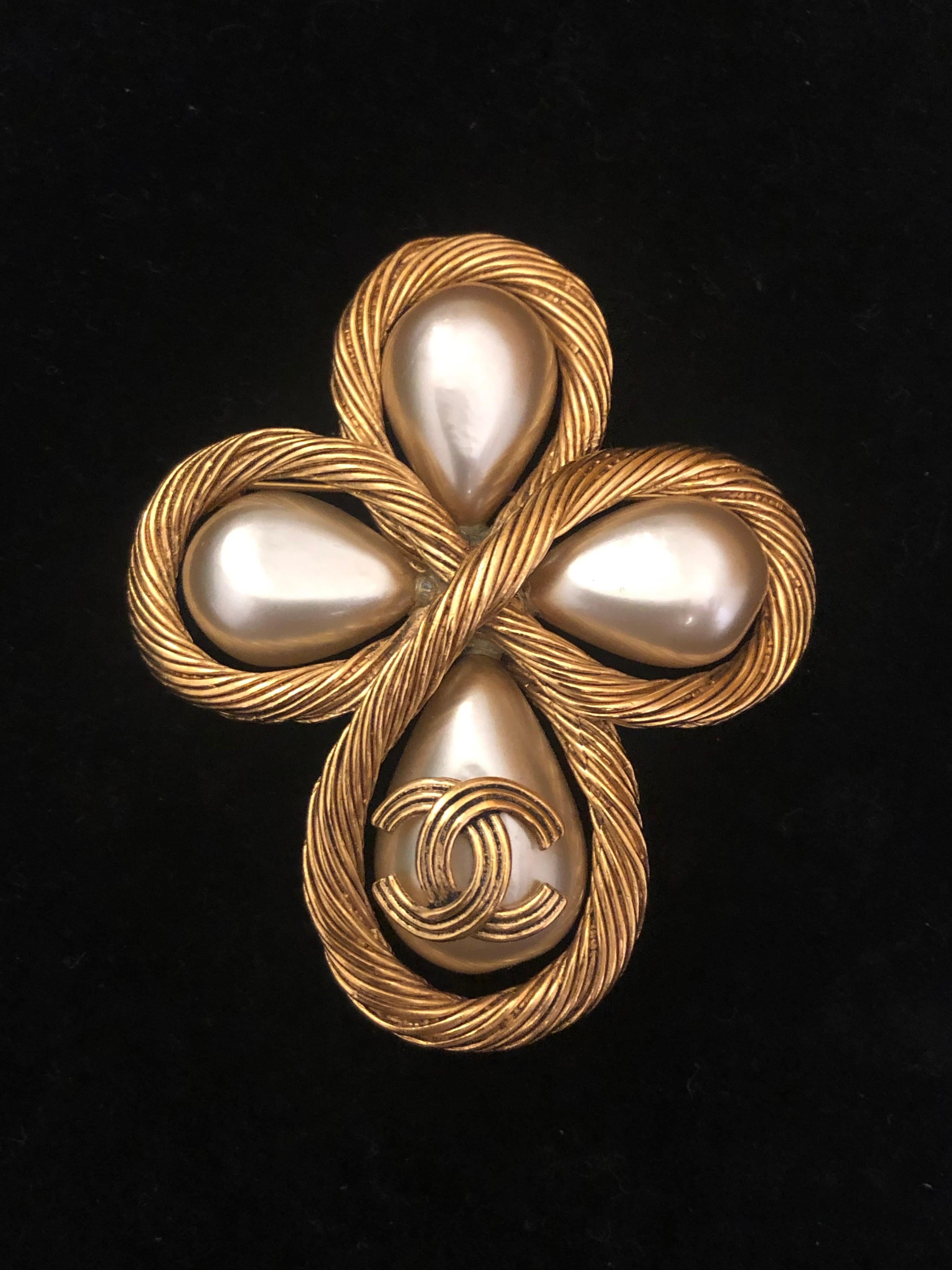 1990s Chanel gold toned brooch featuring four faux pearl drops adorned with a gold toned CC logo on the front. Stamped CHANEL 94A made in France. Measures approximately 7.1 x 6.0 cm. Comes with box. 

Condition: Minor signs of wear. Generally in