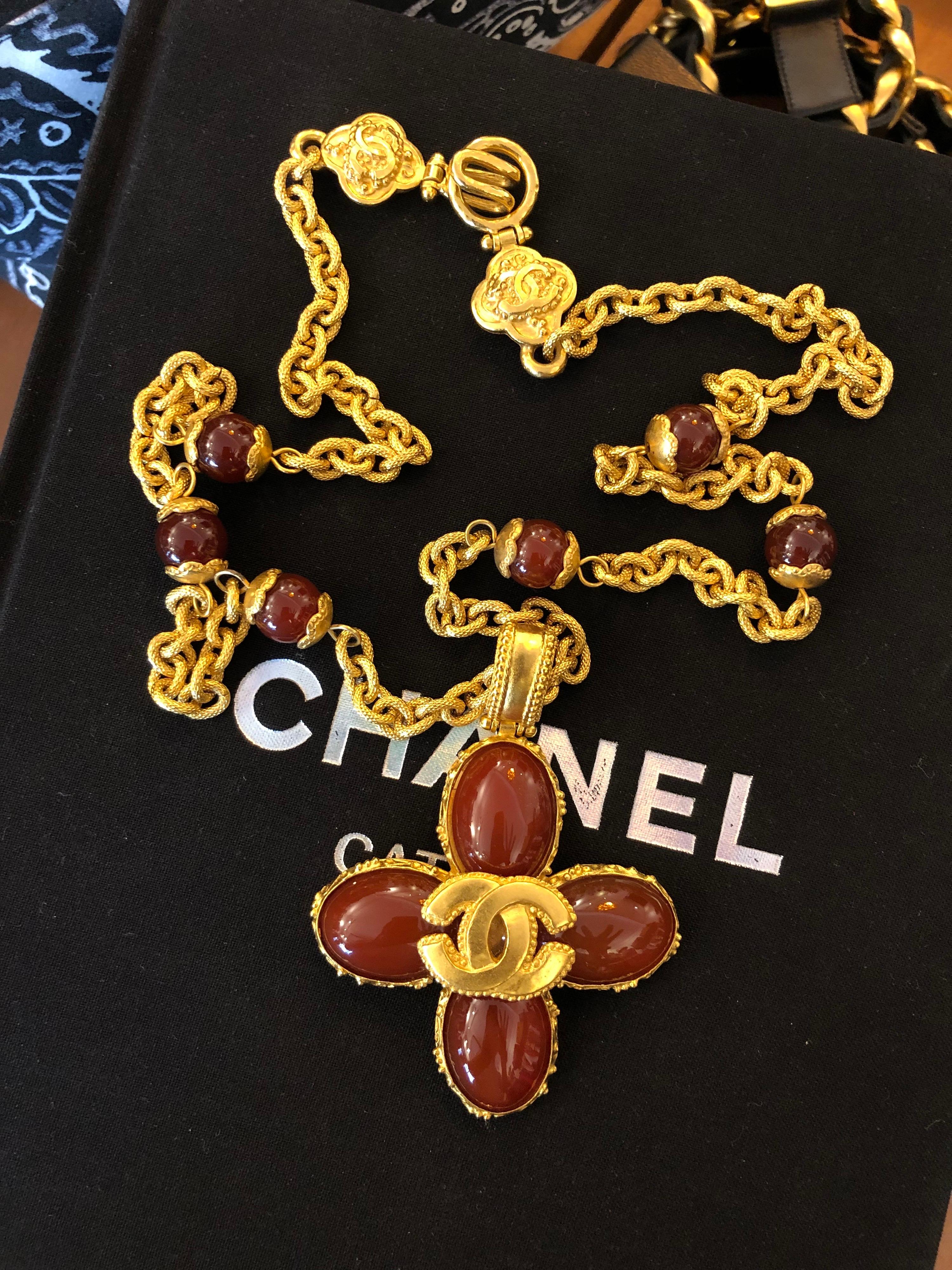 1990s Chanel gold toned textured chain necklace adorned with six semi-precious red carnelian stone beads and a gold toned CC logo mounted on an iconic Chanel clover charm in semi-precious red carnelian stone. Exquisitely crafted from the hooks to