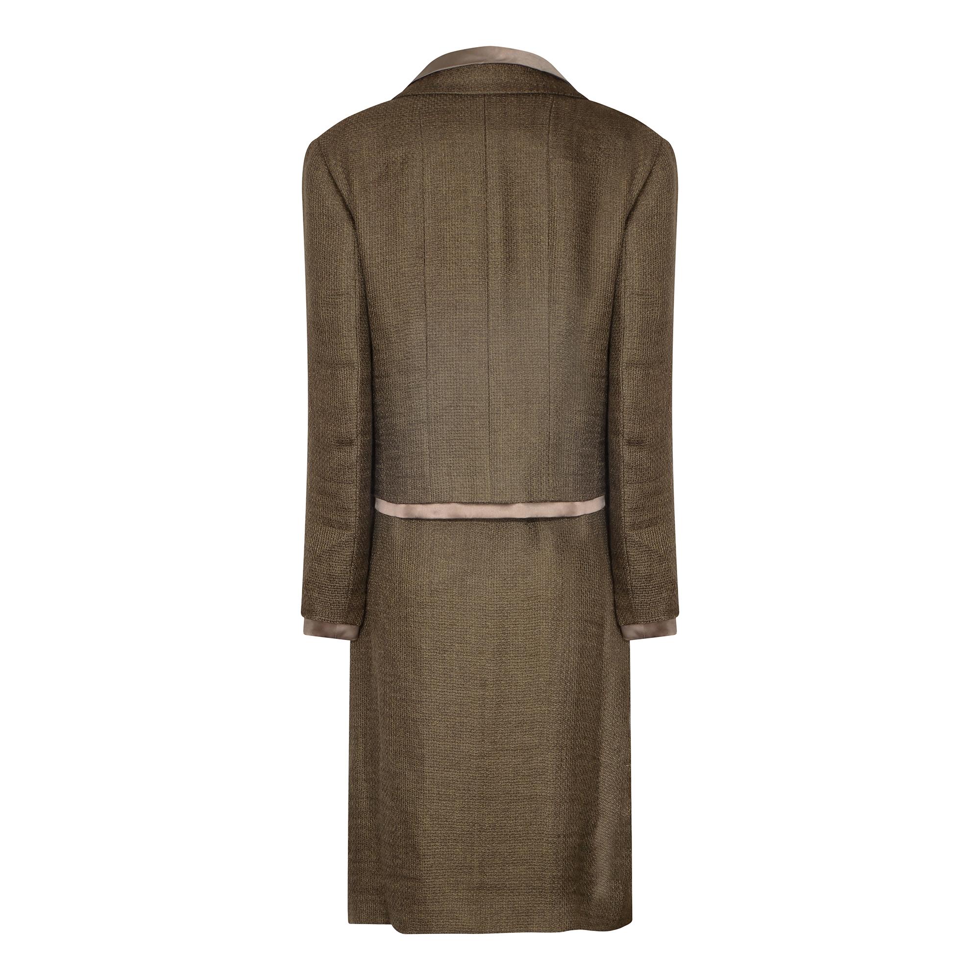 Voici un look sophistiqué de la collection automne/hiver 1999 de Chanel, composé d'un ensemble de trois pièces (jupe, veste et caraco).  La veste croisée en tweed avec deux poches plaquées et la jupe à nouer au genou sont composées d'un mélange de