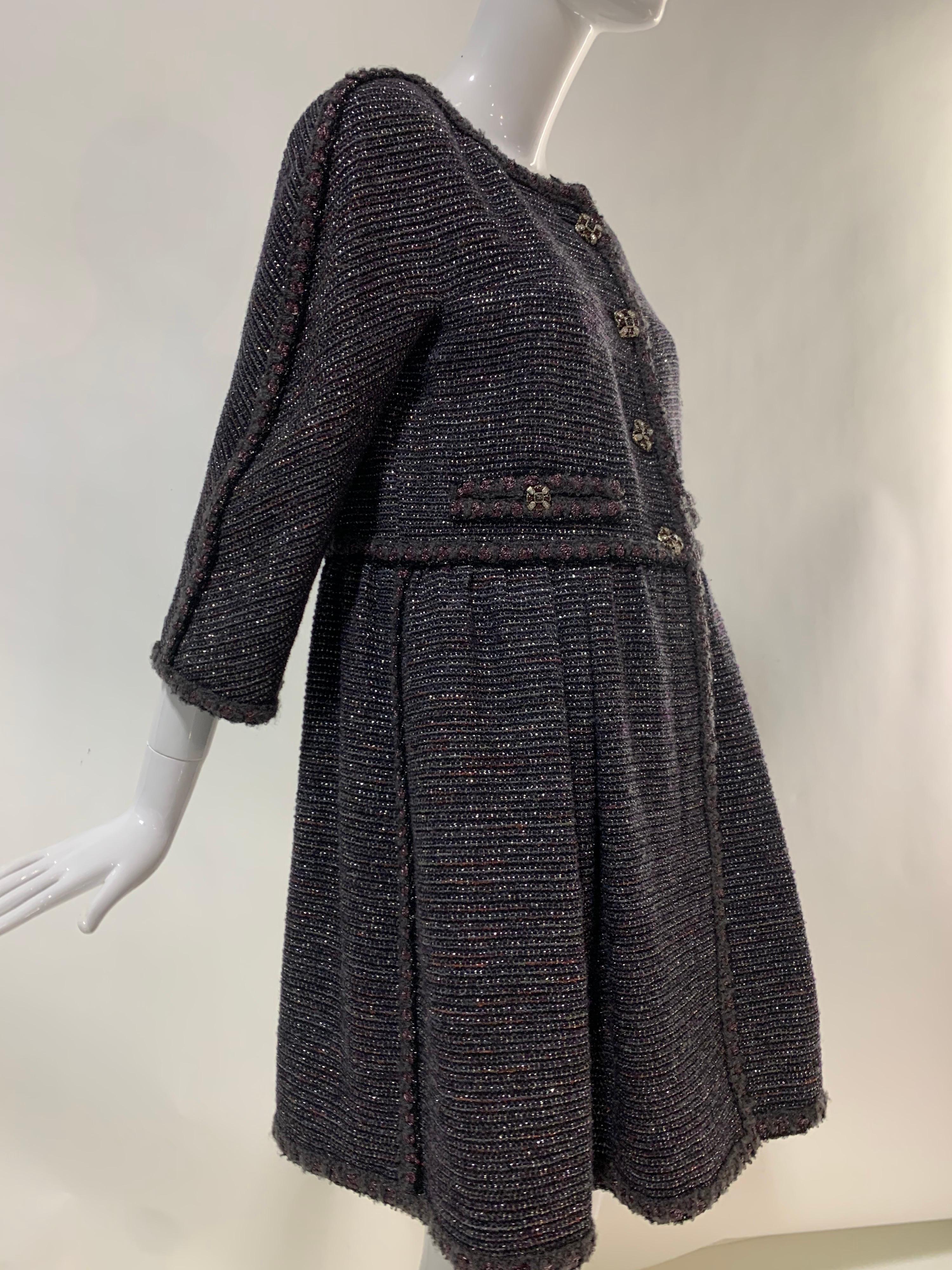 A fantastic 1990s Chanel gunmetal gray wool and lame tweed baby doll coat dress with fringed trim and jeweled buttons. Dolman cut sleeves and faux front pockets. Fully lined in camellia-print Chanel logo silk. Size EU 42.