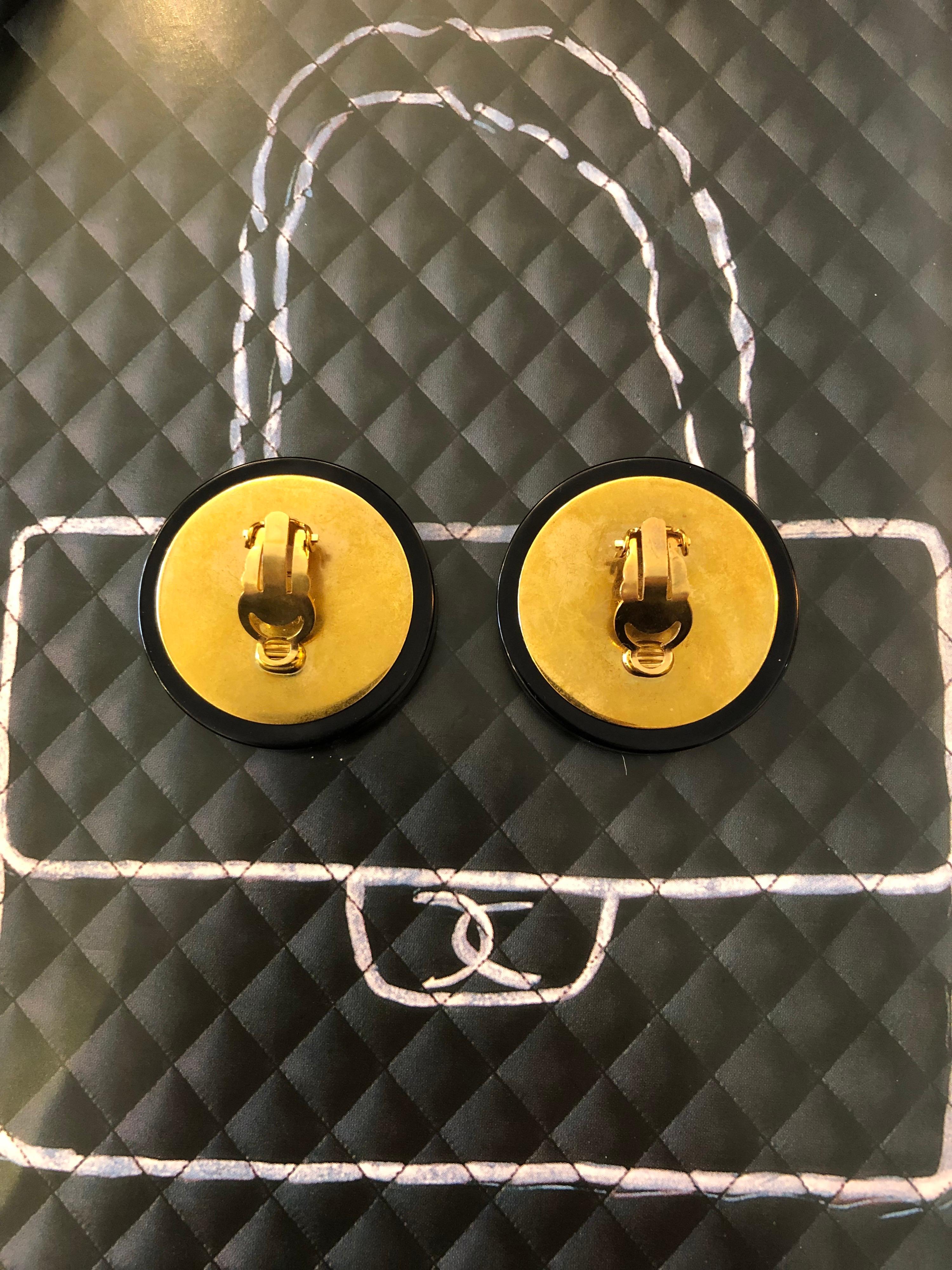 1990s Chanel button earring in black resin featuring a textured gold toned CC. Jumbo Sized. Stamped 28 made in France. Measures 4cm in diameter. Come with box.

Condition - Minor signs of wear. 