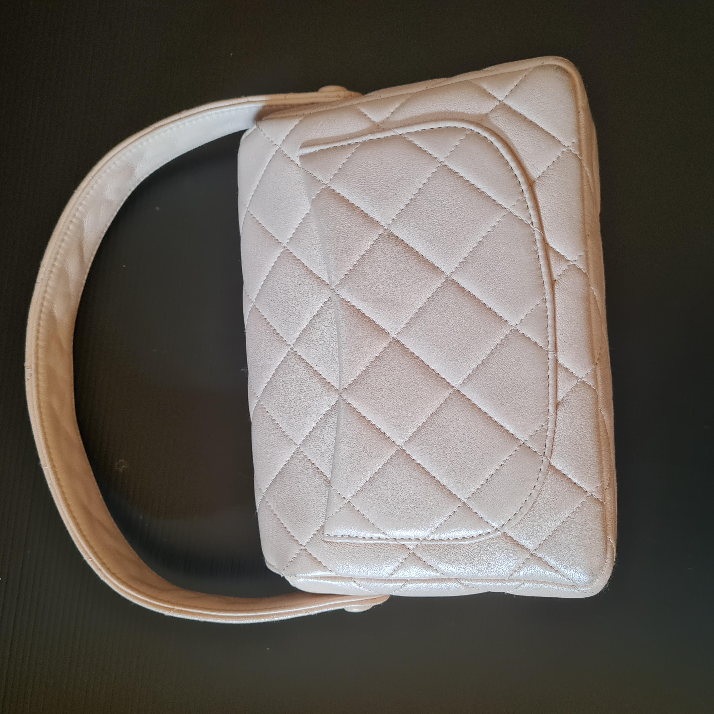 Chanel Kelly Top Handle in light beige colour. Rare vintage bag perfect for everyday wear and evening wear. Beautiful lambskin with minor rubbing on the corners. 

Inclusion: Dust Bag

Serial Number: #3974191

Closure: CC Turn-Lock
