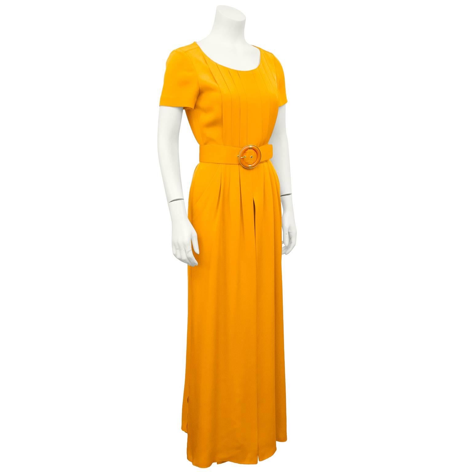 Gorgeous 1990s Chanel boutique bright orange silk jumpsuit. Short sleeve with a slight scoop neckline, vertical pleating throughout bodice. Belted at waist with monochromatic orange belt with gold tone metal and orange resin buckle with gold tone cc