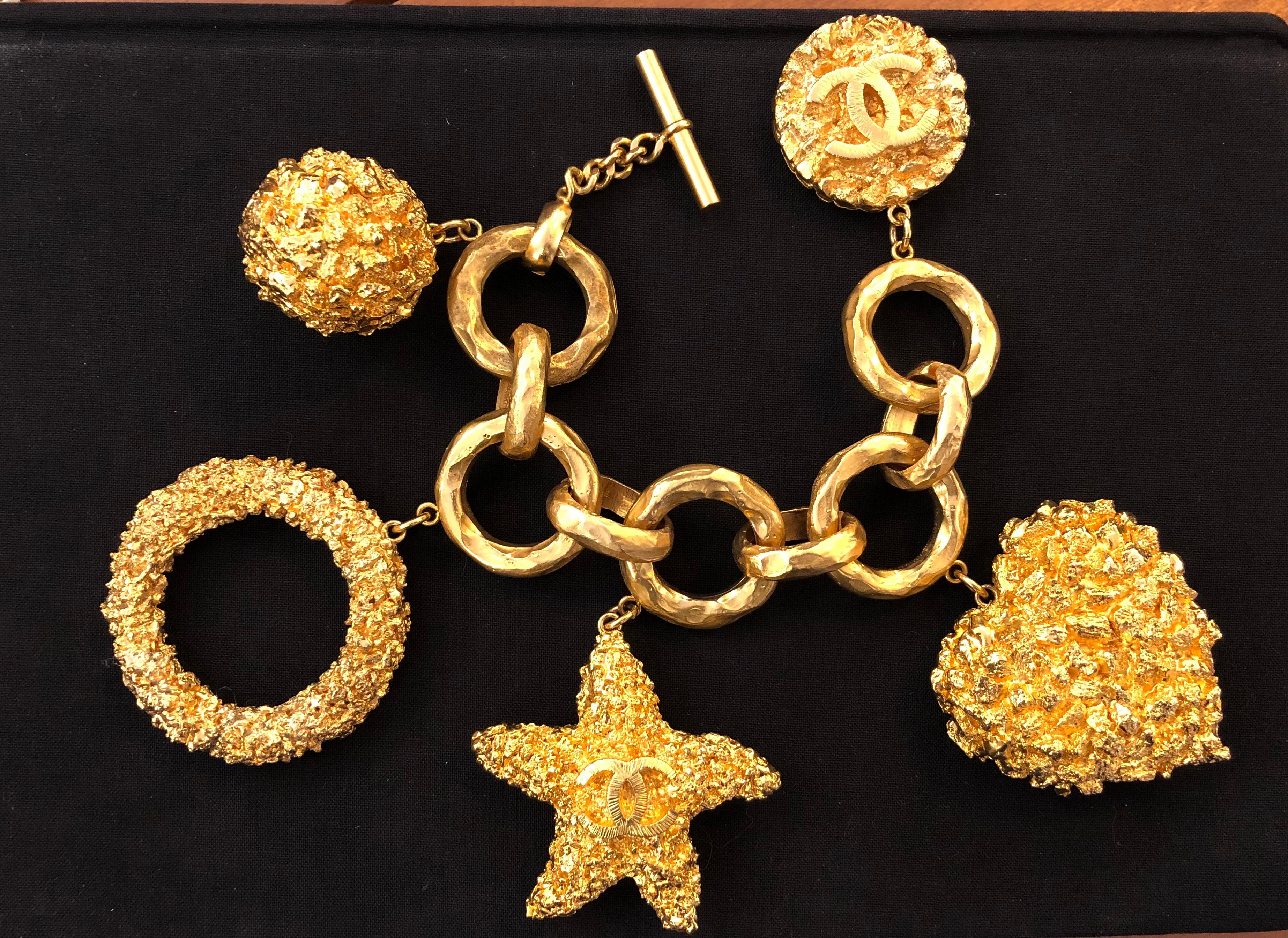 From Chanel 1993 Cruise collection, this huge gold toned bracelet features five gold toned textured motifs including a CC starfish. It was featured in 1993 Cruise collection Ad campaign. An absolutely rare piece to add to your vintage Chanel
