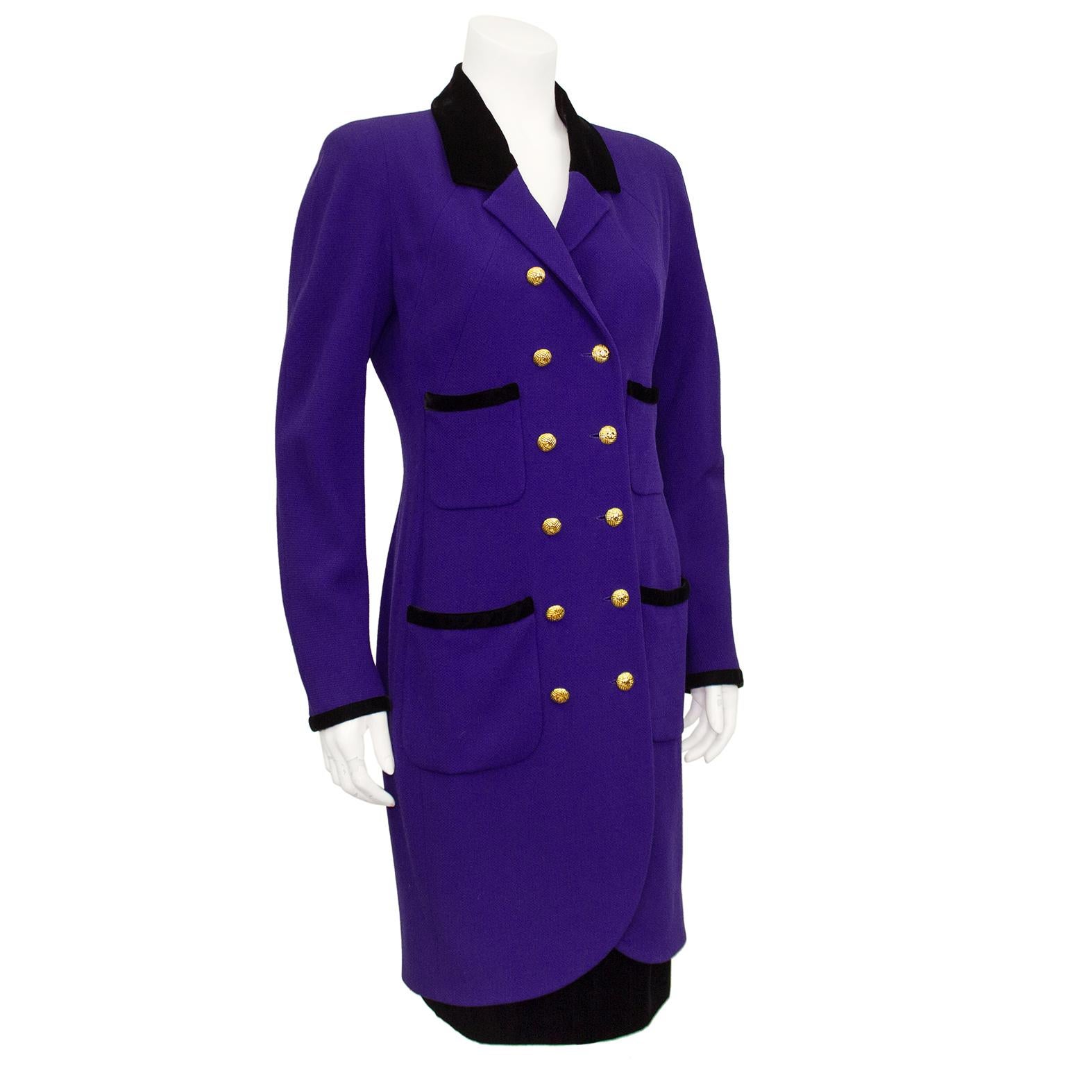 Chanel coat dress and skirt ensemble from the 1980s. The deep purple wool of the coat dress is contrasted by the jet black cut velvet collar and trim. Double breasted with gold tone metal Chanel logo buttons. Four patch pockets with velvet trim.