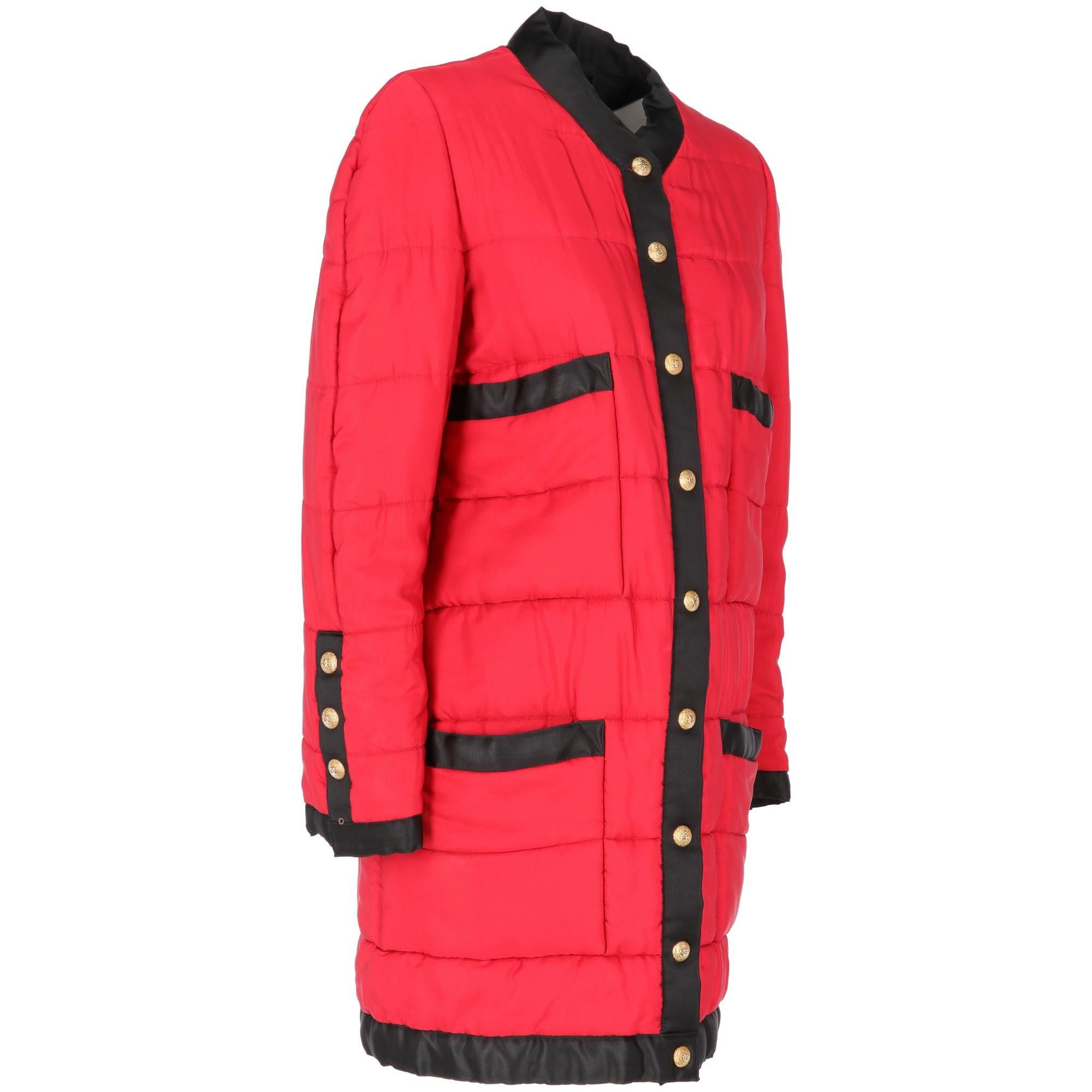 The stylish Chanel black and red quilted duffle coat features a round neckline, front patch-pockets, gold-tone and silver-tone metal buttons with logo on the front buttoned fastening and on the sleeves. With black silk lining, the item shows some