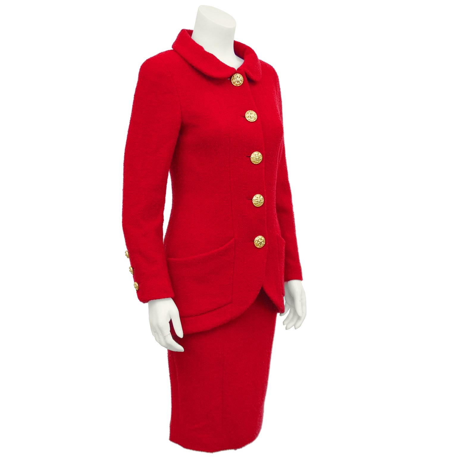 1990 Chanel red boucle skirt suit, marked collection 29. The jacket has a Peter Pan style collar and tulip cut away style hemline. Beautiful and large 'woven' goldtone buttons up the front and matching smaller versions on the cuffs. Two front patch