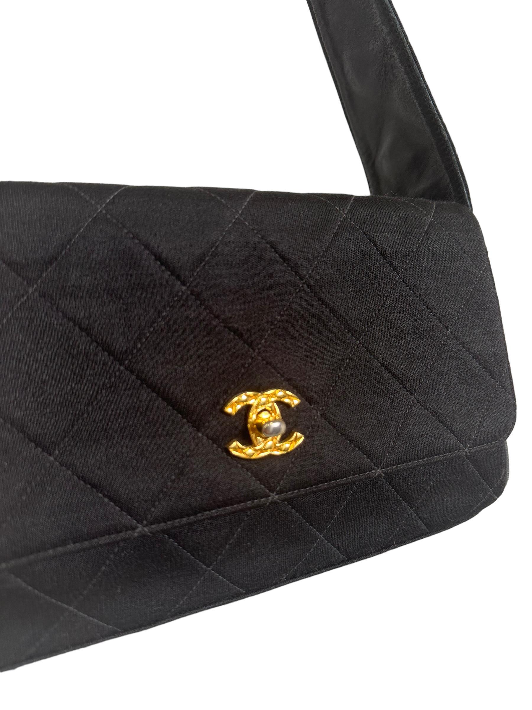 Chanel signed bag, vintage model, made of black quilted canvas with golden hardware. Equipped with a flap with twist lock with CC logo, internally covered in black leather, quite large. Equipped with a canvas shoulder handle and internal pockets