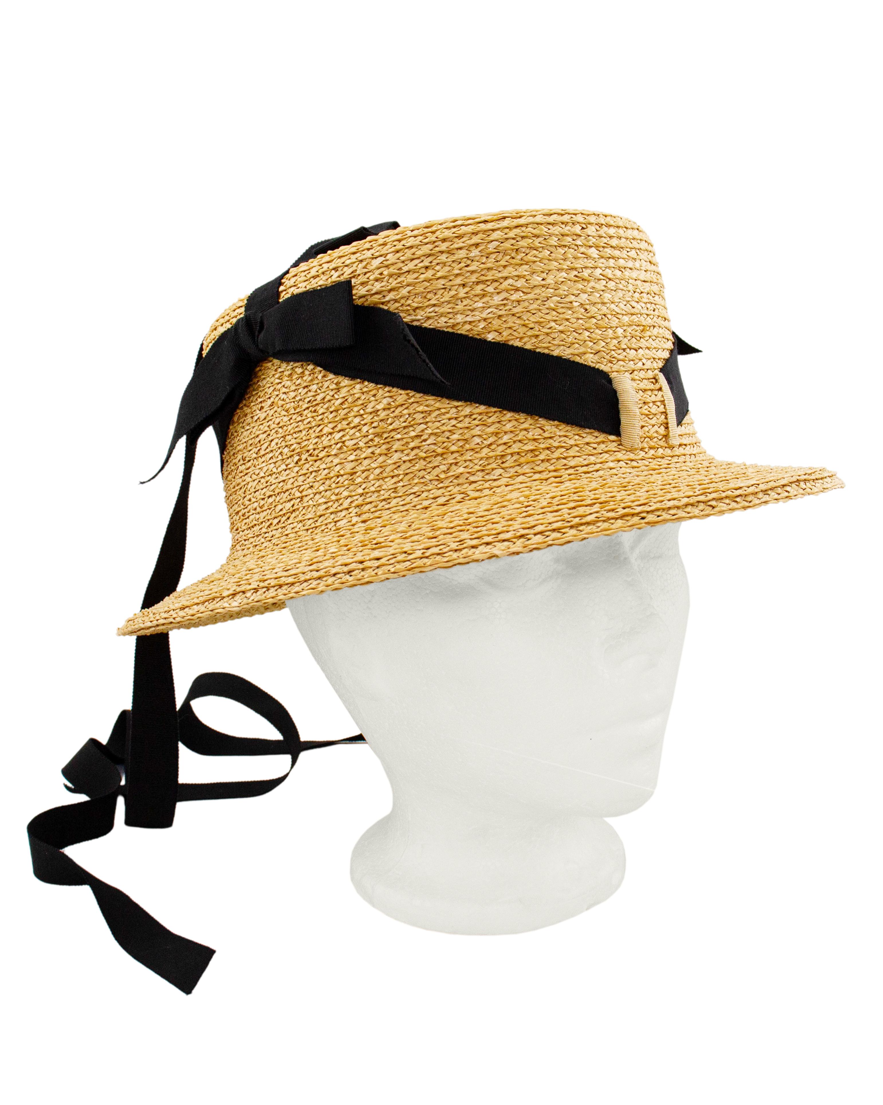 Chapeau Chanel des années 1990 de style seau en paille naturelle avec un ruban noir en gros-grain tissé à travers la couronne, au-dessus de la couronne et des rubans auto-nouants supplémentaires pour sécuriser en cas de brise. En excellent état,
