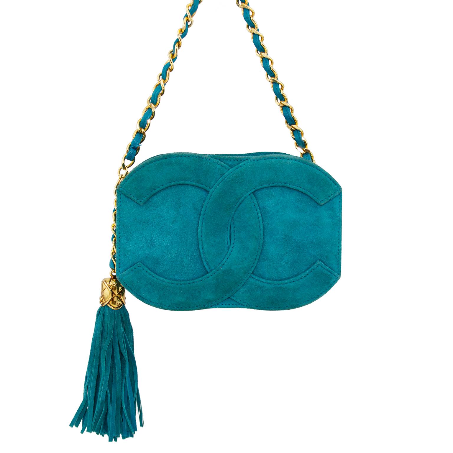 Looking for small daytime and evening bag with a pop of colour? This Chanel bag is for you. teal suede with a large interlocking cc logo on the front and back. The corners of the rectangular shape are rounded with the curve of the logos. Large and