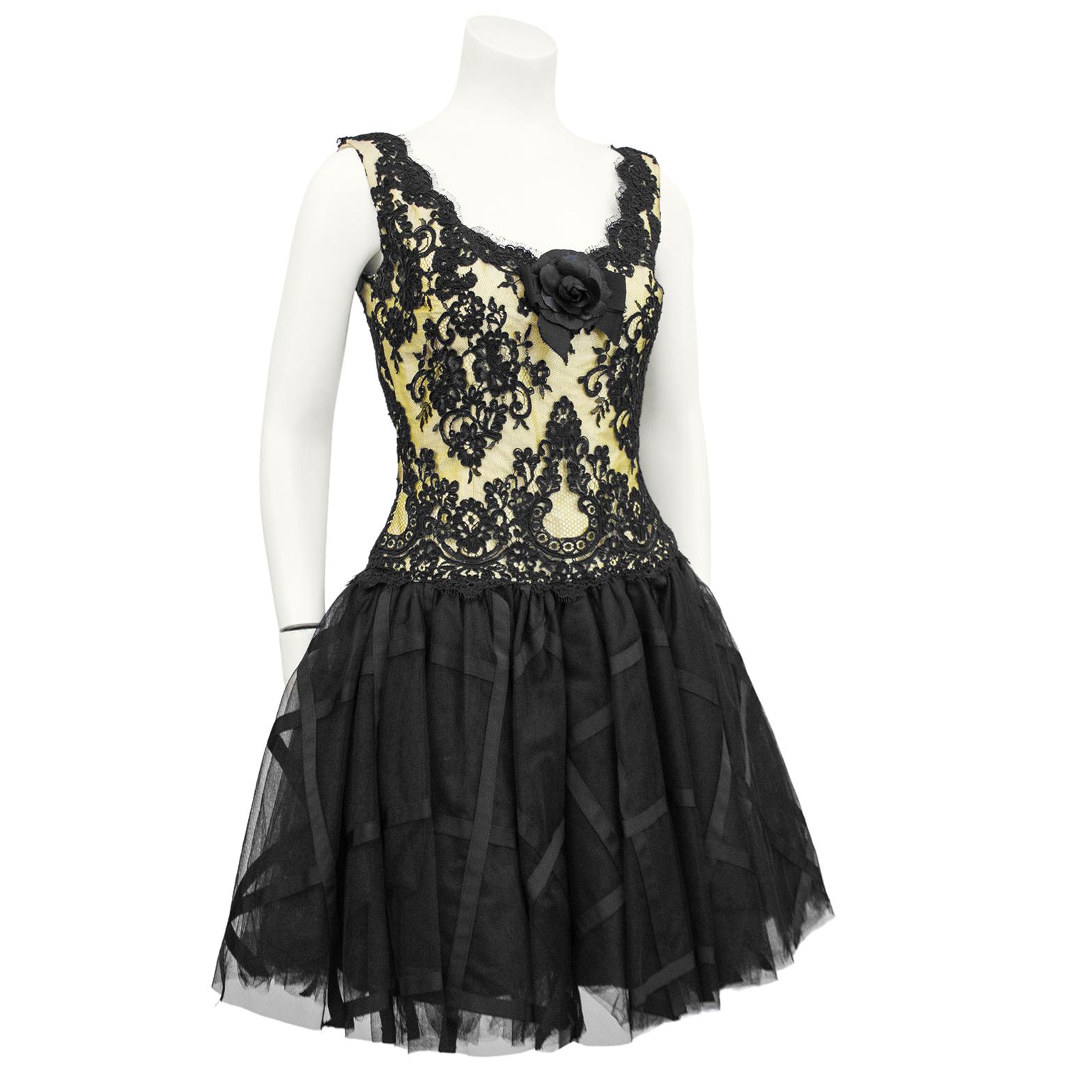 1990's Chris Kole cocktail dress. Bodice features yellow fabric under black lace with rosette and bow at centre of open sweetheart  neck. Lace scalloped  at neckline and low back. Drop waist. Skirt is a short tutu style  made from tulle and satin