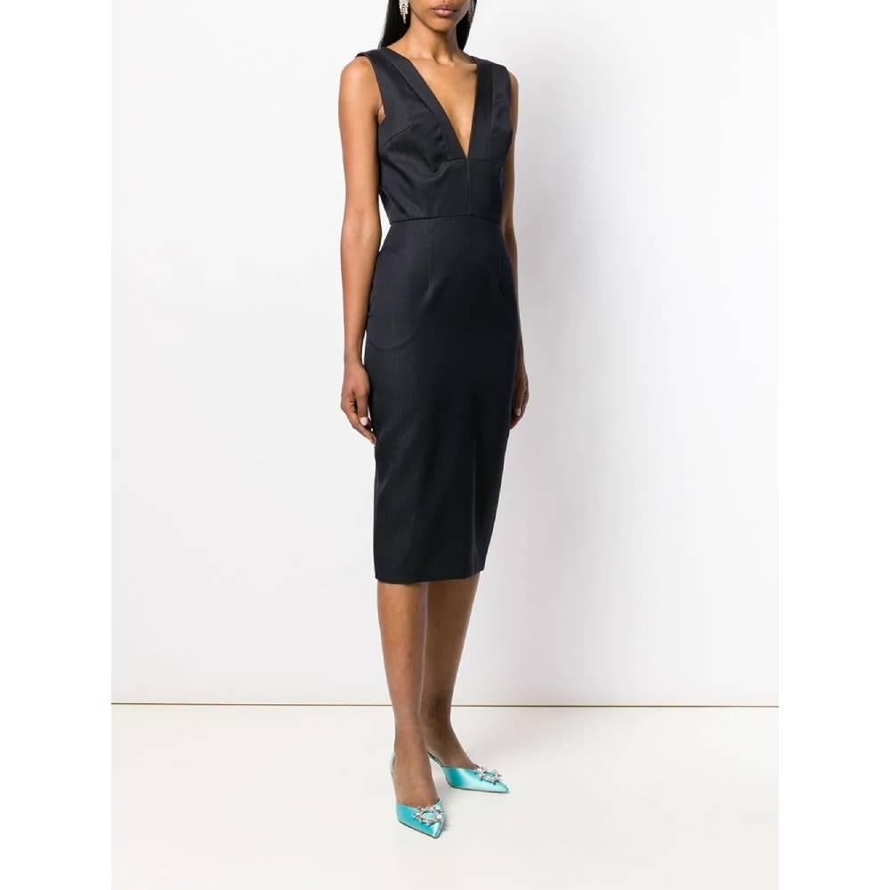 Christian Dior black fitted dress. Sleeveless model with deep V-neck, welt pockets inserted in the seam and fastening with zip and hook on the back. Below the knee length and small back split.

The product has a small darning near the slit on the
