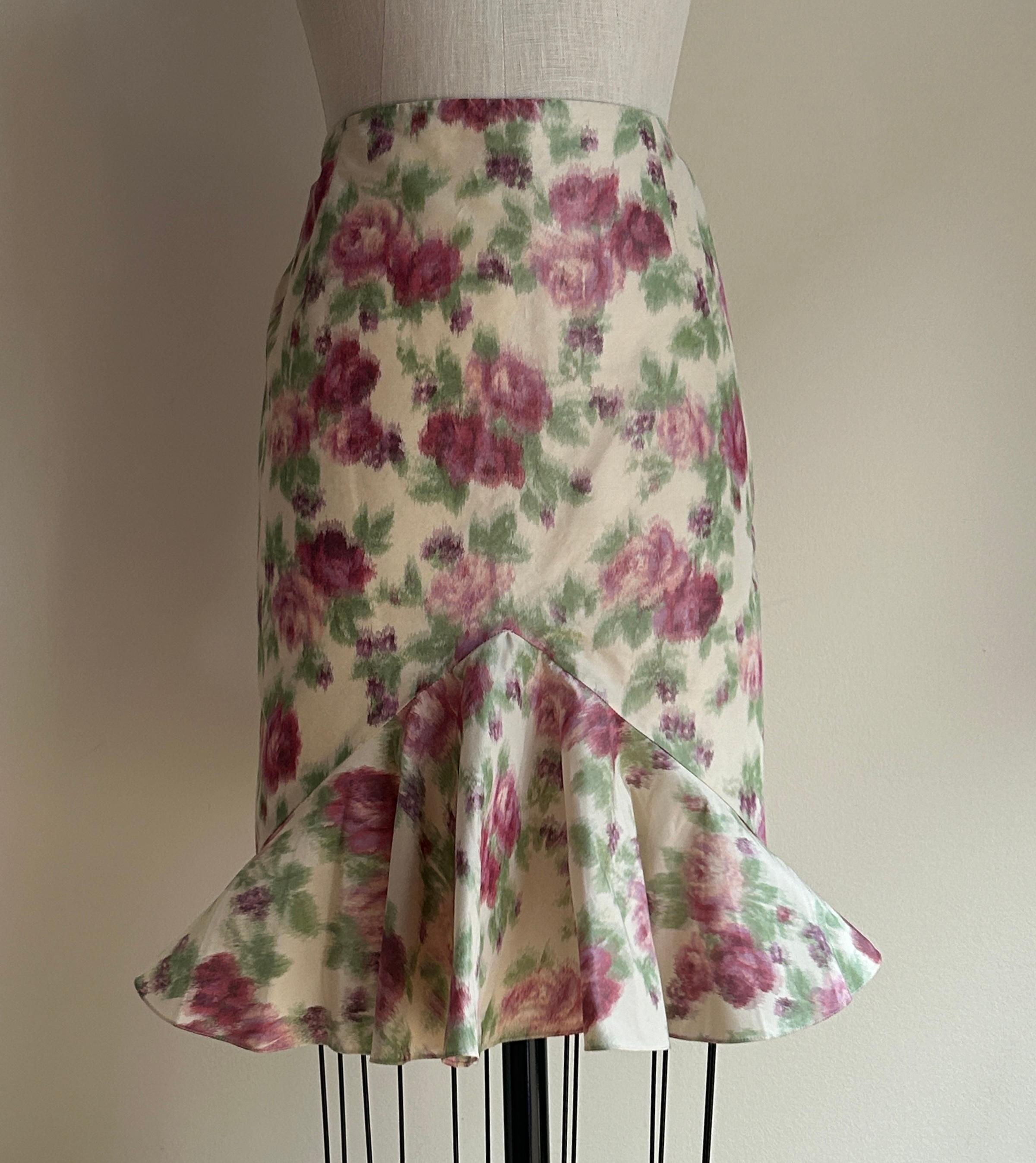 Vintage Christian Dior Boutique pencil skirt with a triangular flared ruffle at front hem. Such a cool and sculptural shape! Features a pink and pale plum rose pattern in a blurred watercolor effect.  Side zip and hook and eye. 

By John Galliano