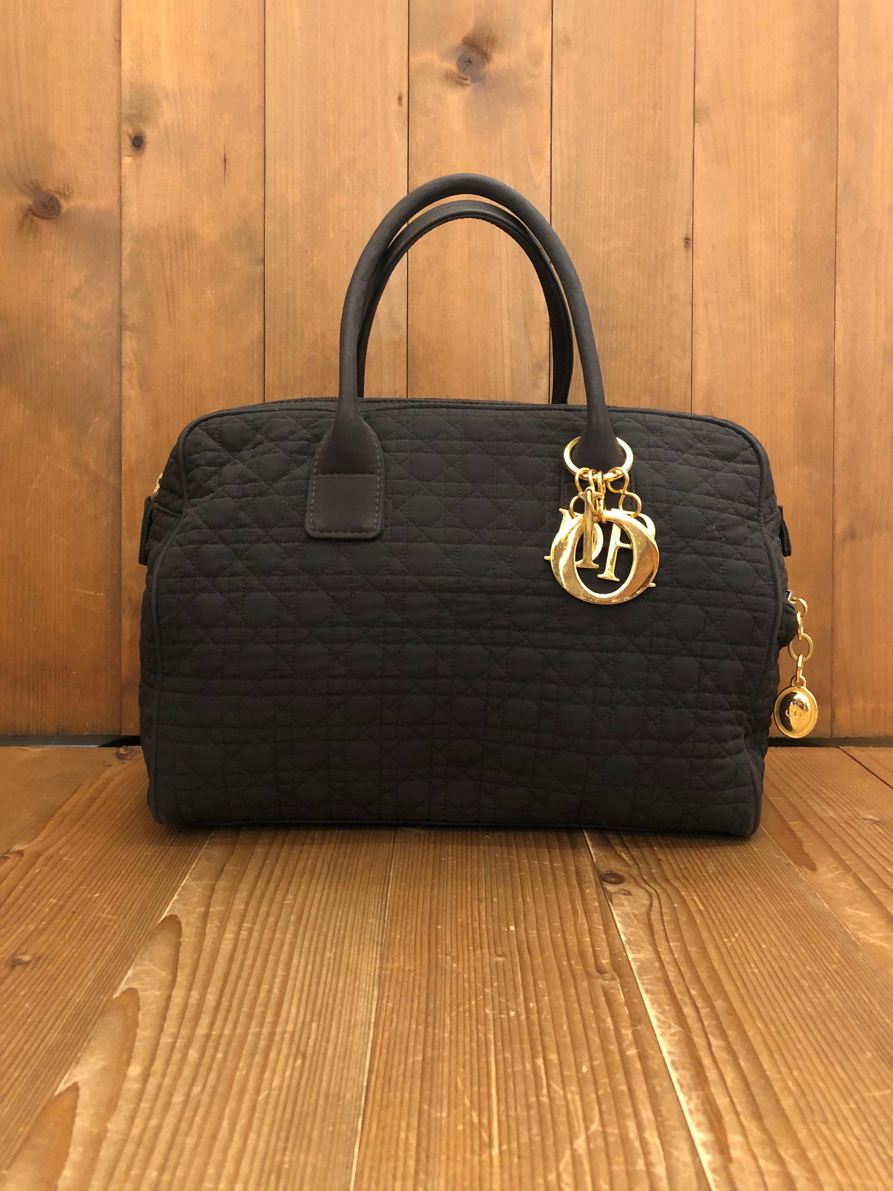 This 1990s CHRISTIAN DIOR Lady Dior boston handbag is decorated with a cannage in dark brown nylon and gold toned hardware featuring one interior zip pocket and exterior side zip pocket. Made in Italy. Measures approximately 12 x 9.5 x 5.5 inches