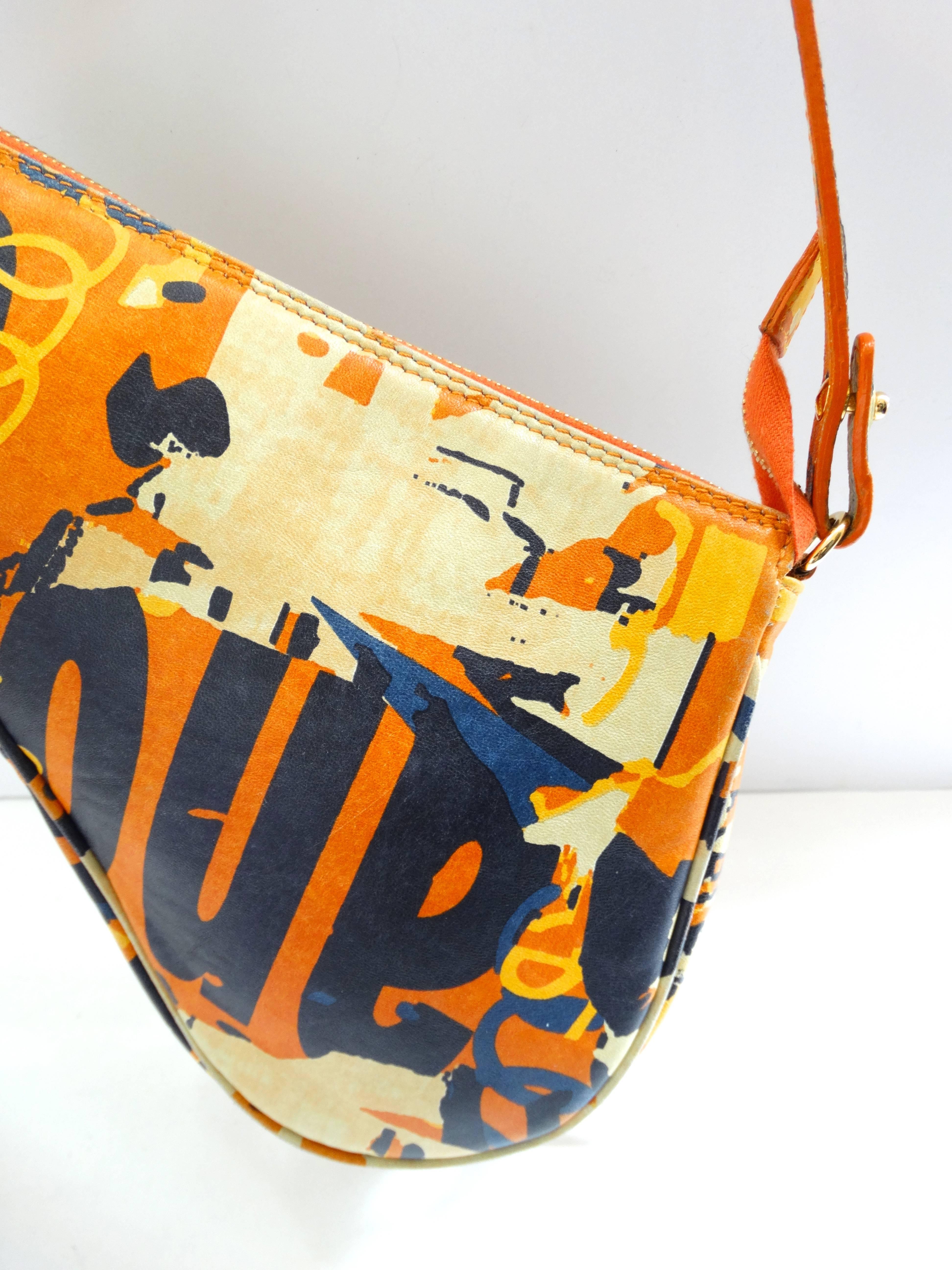 Who doesn't love a little Galliano era Dior? We sure do! This amazing saddle bag comes straight to you from the 1990s- with its bold orange printed leather and over the shoulder strap. Classic Dior saddle bag construction with gold metal CD charm