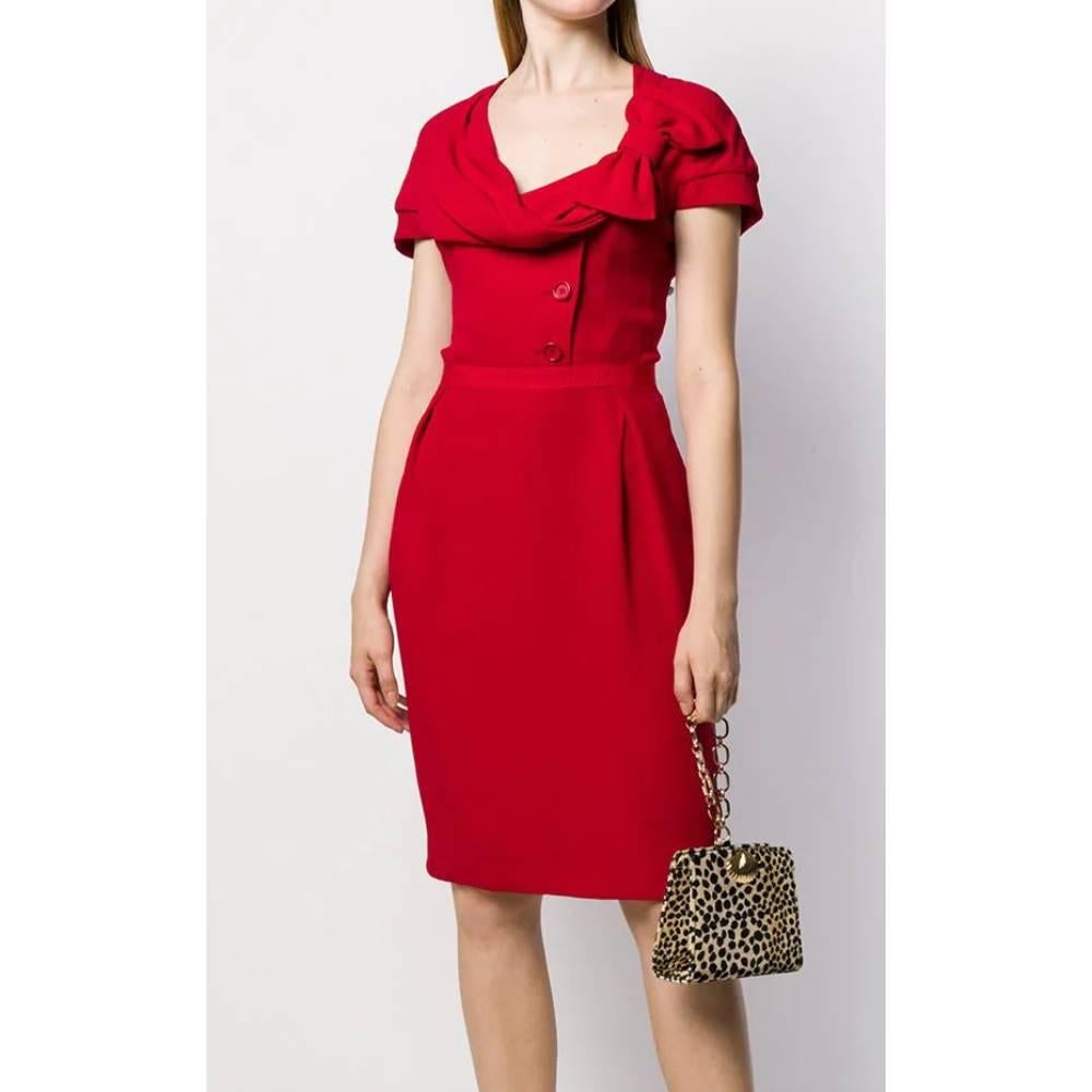 Christian Dior red silk dress, knee length, round neckline with draping, and decorative side bow, decorative oblique buttons, fitted waist, back closure with zip and slit on the bottom. Lined.

Years: 90s

Made in France

Size: 42 FR

Linear