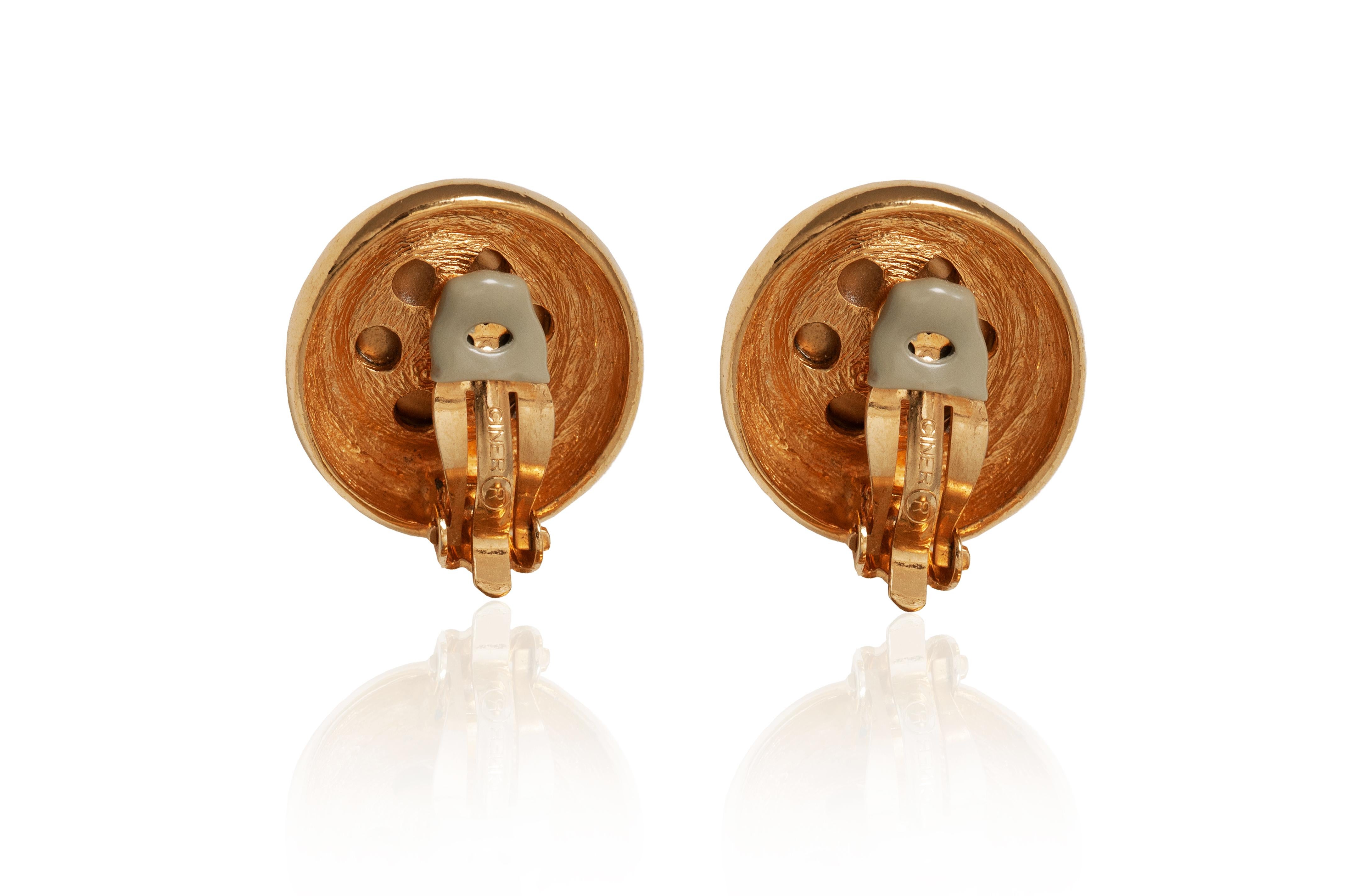 A statement pair of 1990s Ciner burnished gold tone metal clip on earrings. These striking earrings are very similar to Chanel button earrings and have the most amazing soft gold hued half sphere set onto a gold plated base. Signed on the back