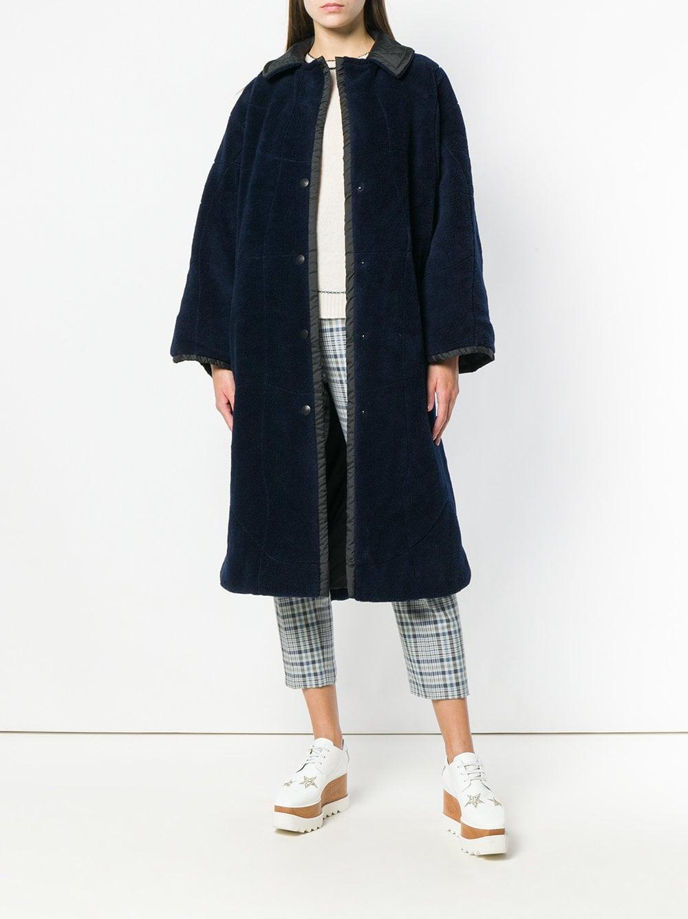 State of Claude Montana blue long oversize coat, blue synthetic outer fabric, edges and lining by black fabric, row front press studs closure, two pockets, two inner cuff-bands.
Years: 90s

Made in Italy

Size: 40 FR

Height: 115 cm
Bust: 68