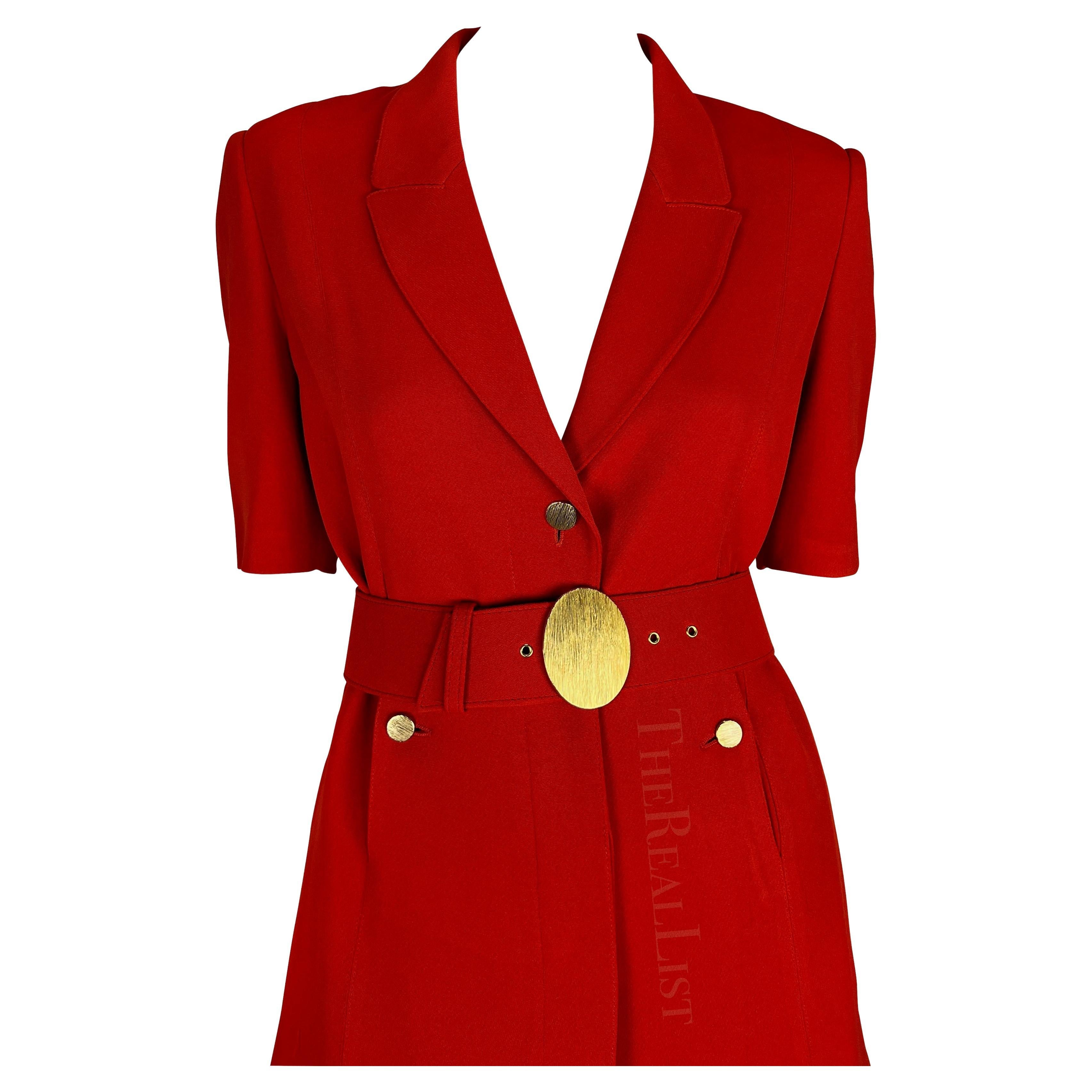 Presenting a fabulous bright red Claude Montana pantsuit. From the 1990s, the suit is comprised of pleated pants, a short-sleeve jacket, and a matching belt. The jacket, adorned with half-length sleeves and exquisite gold-tone buttons that perfectly