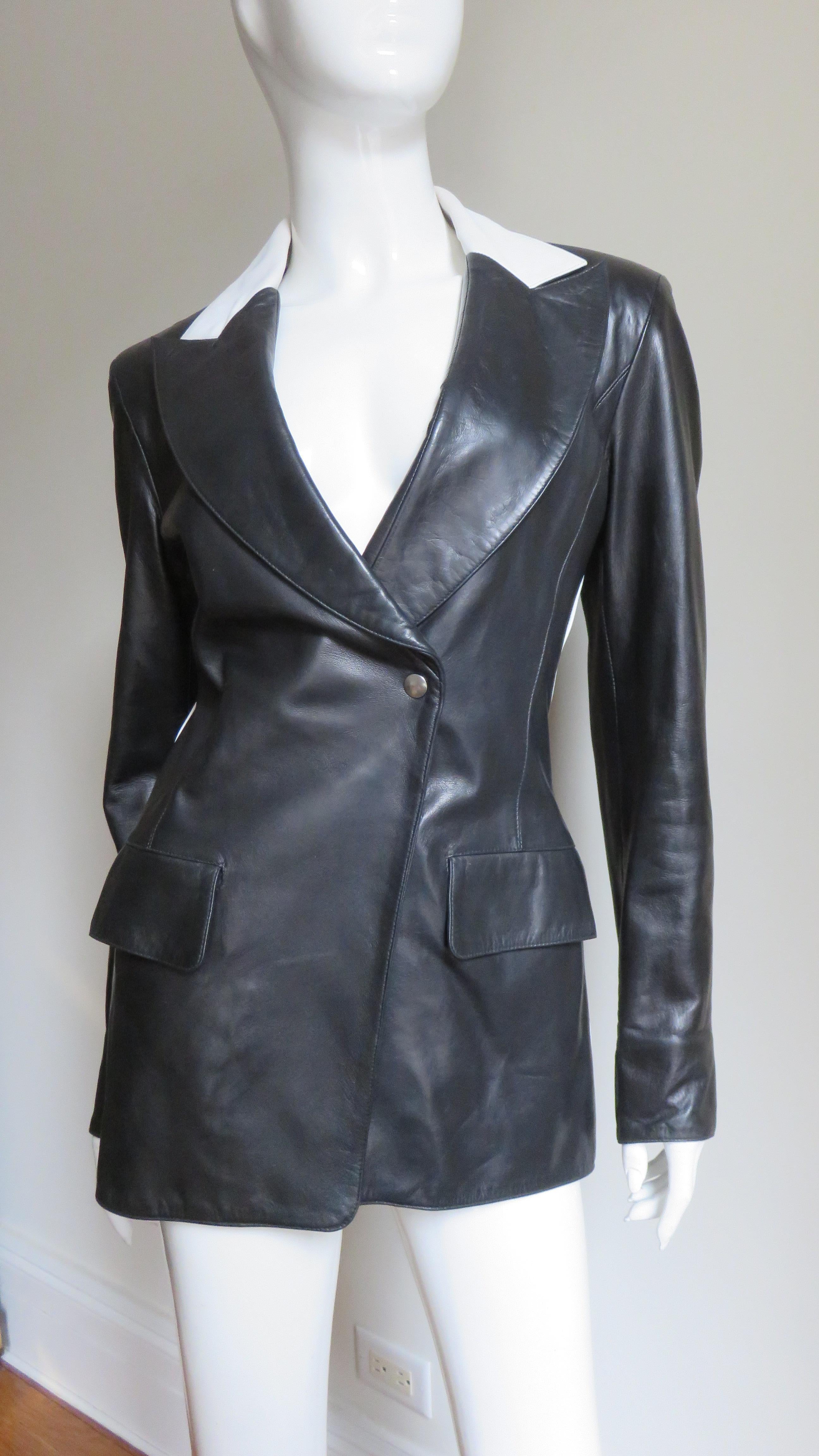 A gorgeous black and white leather jacket by Claude Montana.   It has 1/2 white 1/2 black leather lapel collar, long sleeves with zippers at the wrists and 2 front flap pockets. The back is cut in vertical panels the seams highlighted with white
