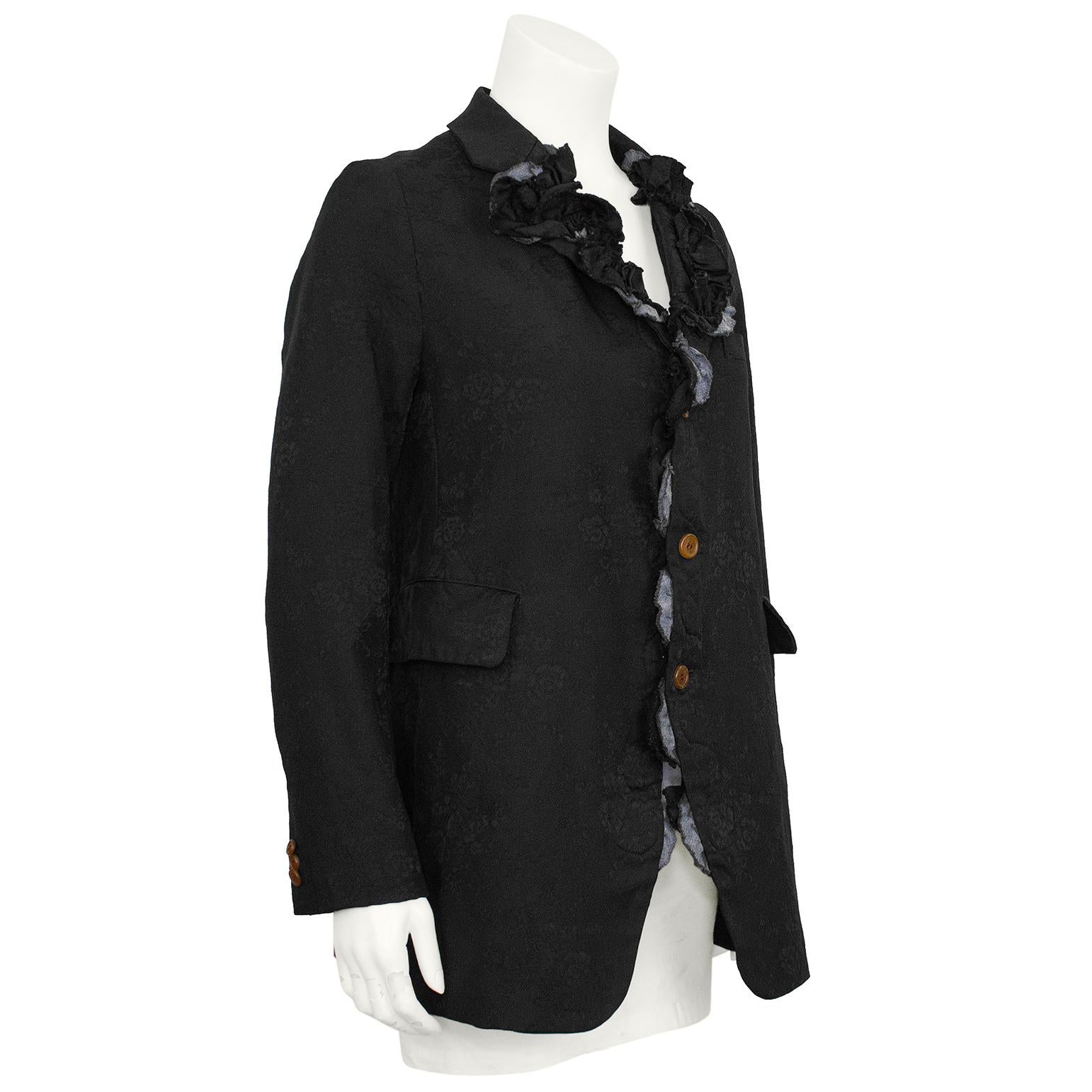 Comme des Garcons black blazer with applique from the 2015 collection. Known for unique fabrics as well as designs, this blazer is made from black Jacquard with a floral bouquet motif. The style of the blazer is long with a curved hemline and two