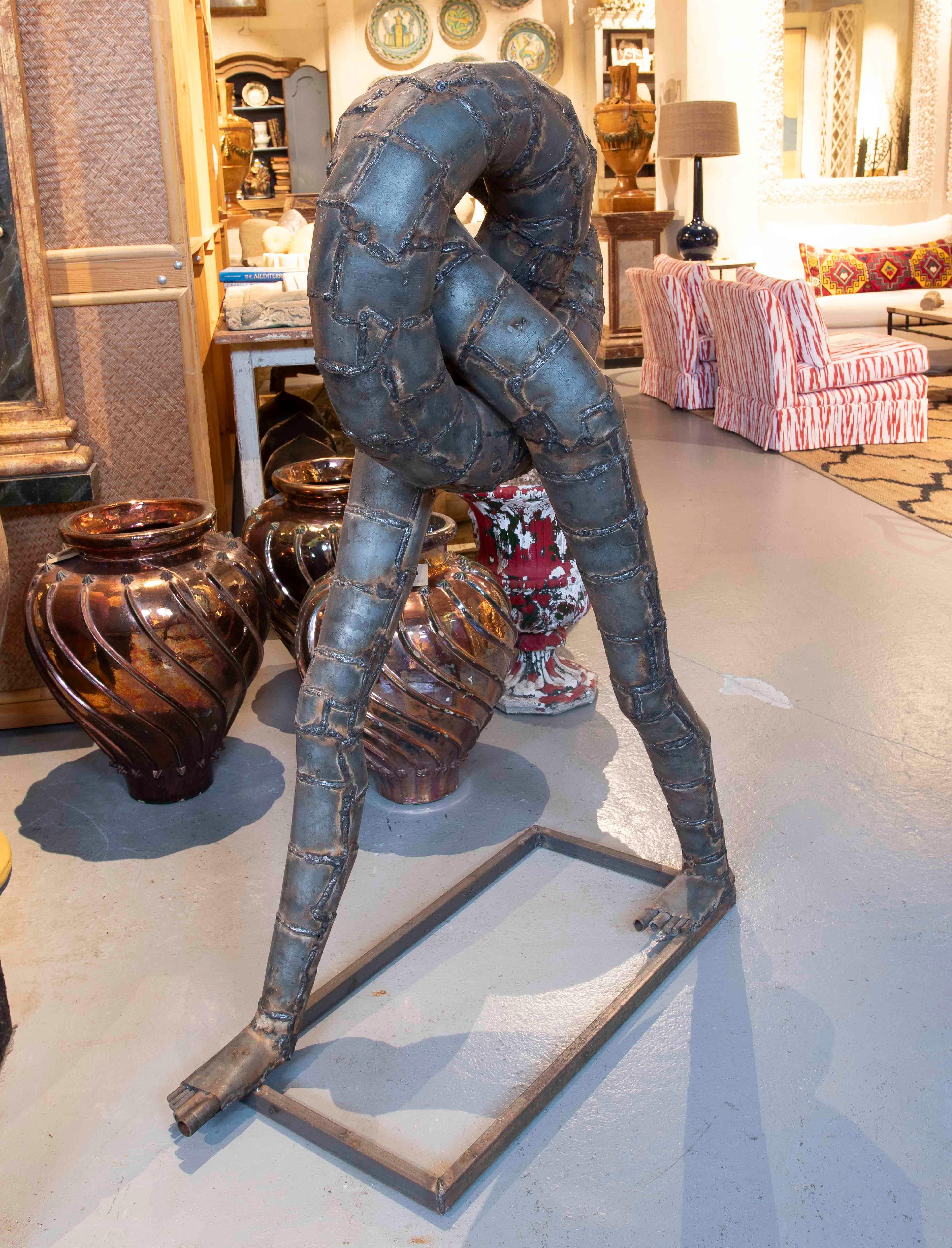 Stunning contemporary metal sculpture, with an abstract and avant-garde design that fuses organic shapes with an industrial aesthetic. The piece represents a twisted tubular structure, with a welded finish that highlights the joints and provides a