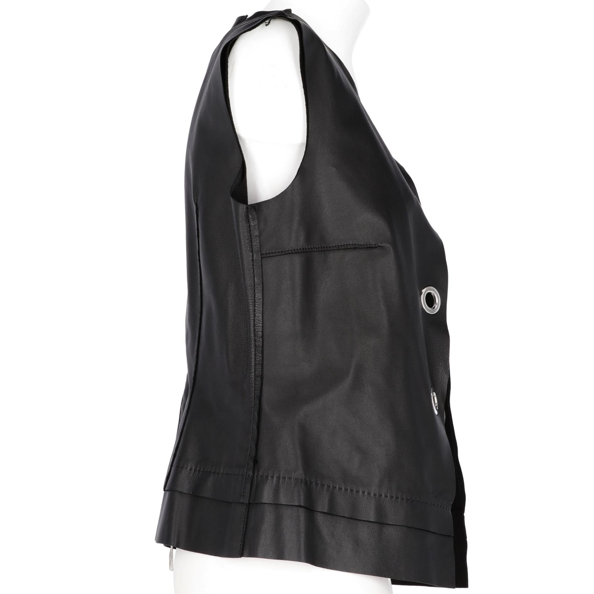 The stylish Costume National black leather vest features silver-tone metal decorative buckles on the front and a decorative zip at back. With raw cut edges and visible stitchings, the vest is lined and in perfect conditions.

Years: 1990s
Made in