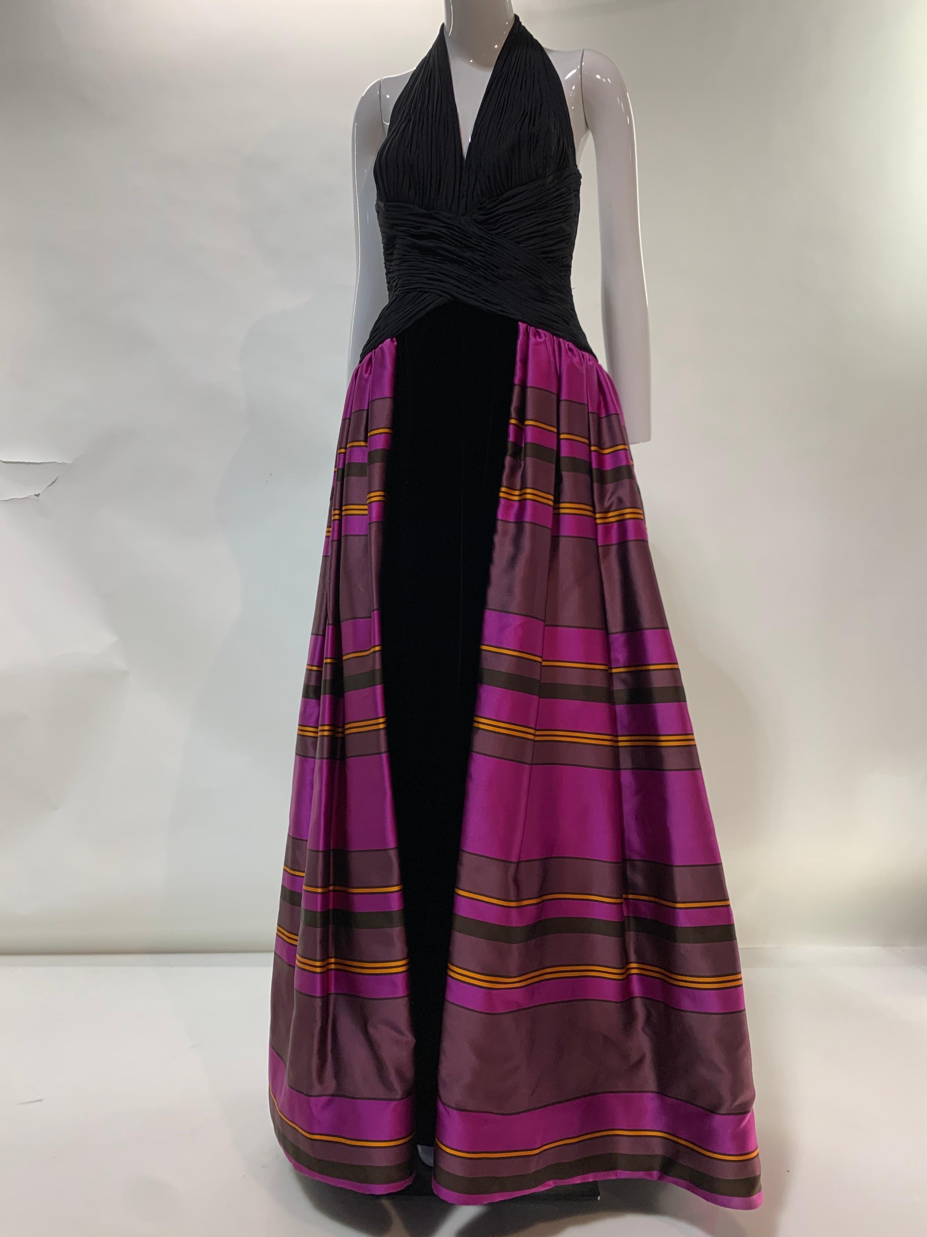 1990s Couture low-back halter gown with ruched black silk jersey bodice and full length silk velvet skirt. At sides and back hip is attached a gathered vivid fuchsia striped silk, double layered over-skirt. Back zipper. Boned bodice. Size 8. From