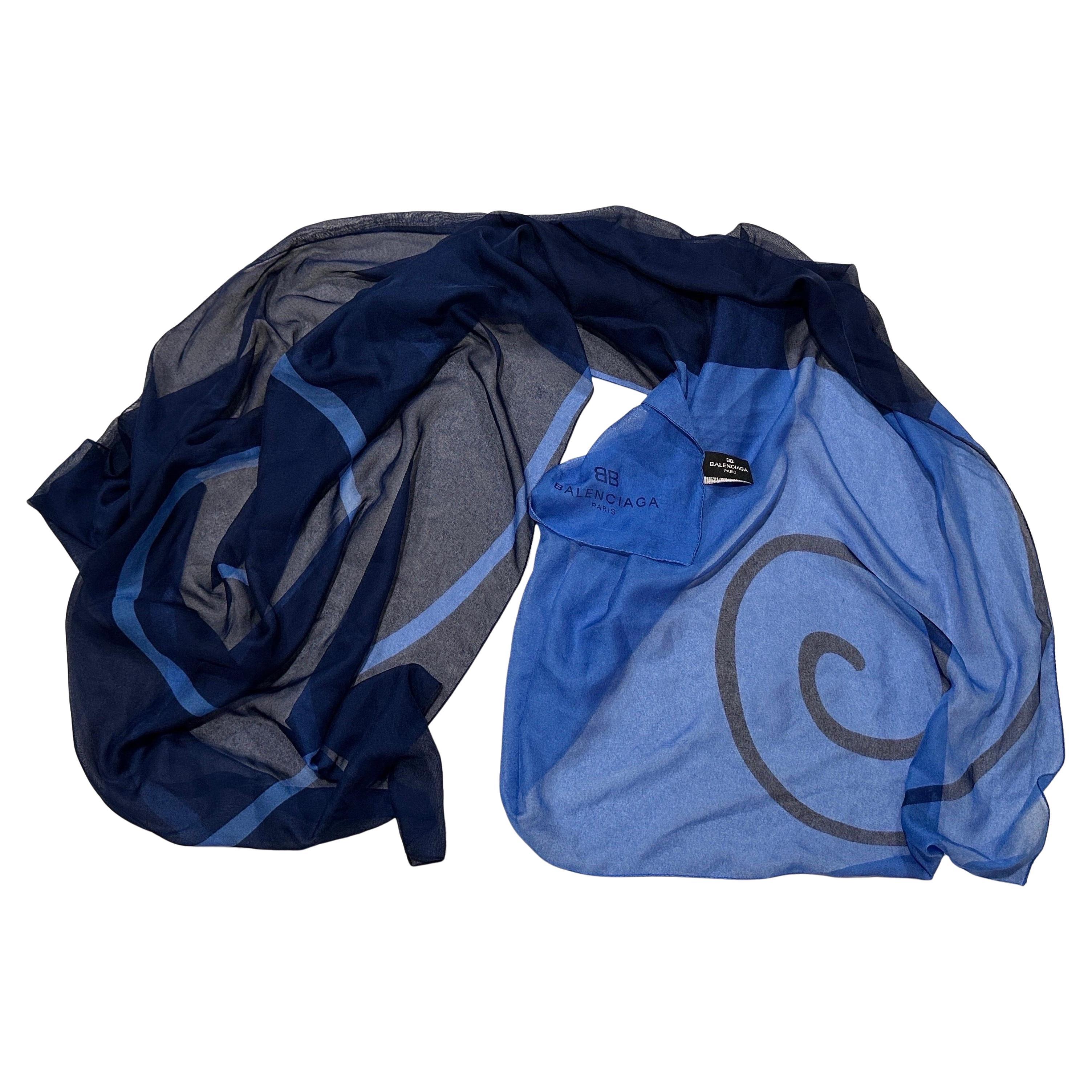 Si tratta di una bellissima sciarpa lunga vintage di Balenciaga Paris. È composto da un tessuto misto trasparente e fluente che gli conferisce un elegante drappeggio.
La sciarpa presenta un design audace, grafico e astratto in varie tonalità di blu,