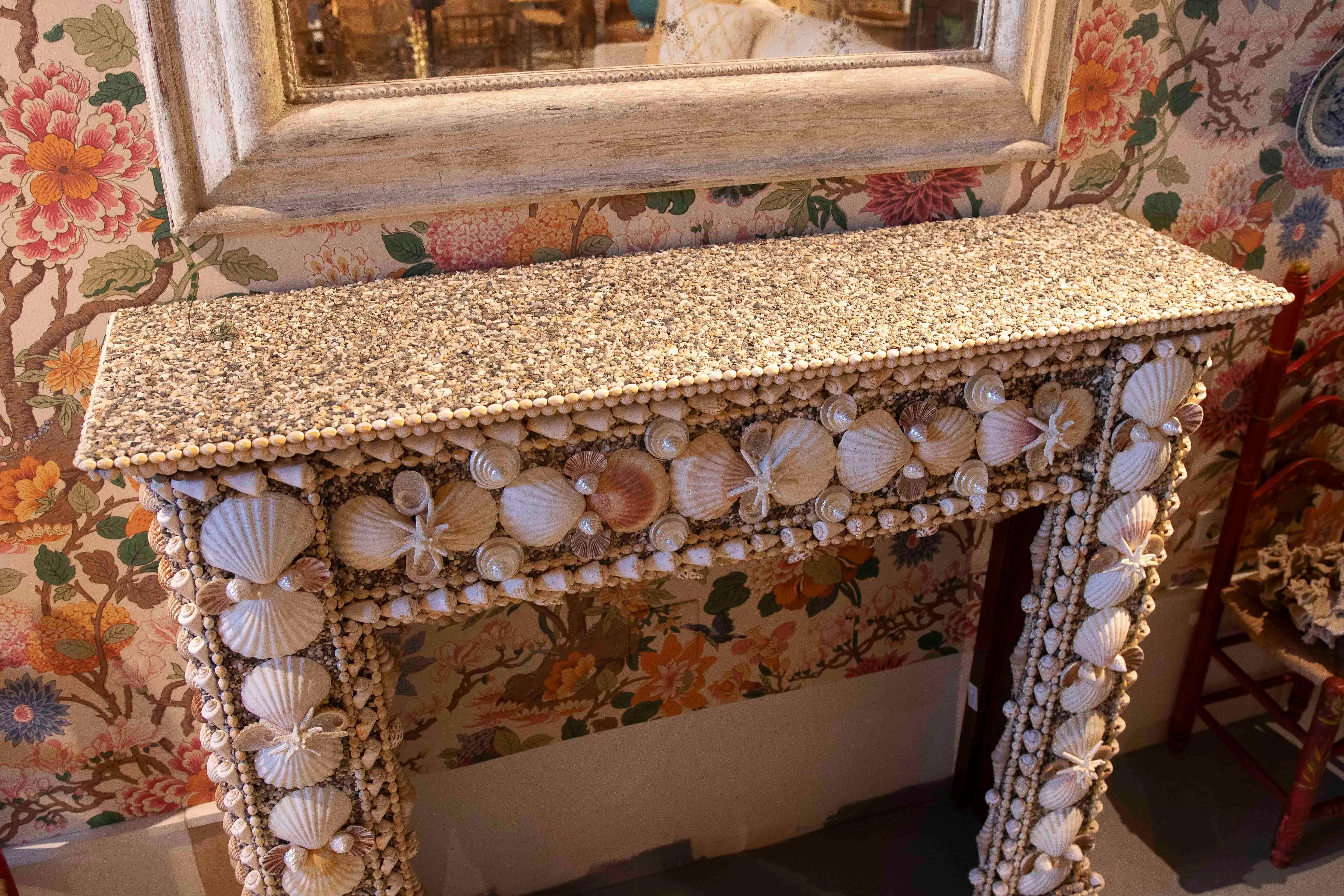 Impresionante repisa decorativa para chimenea completamente cubierta con una exquisita selección de auténticas conchas marinas. Esta pieza única combina la creatividad artesanal con la estética costera, utilizando caracolas, volutas, conchas de