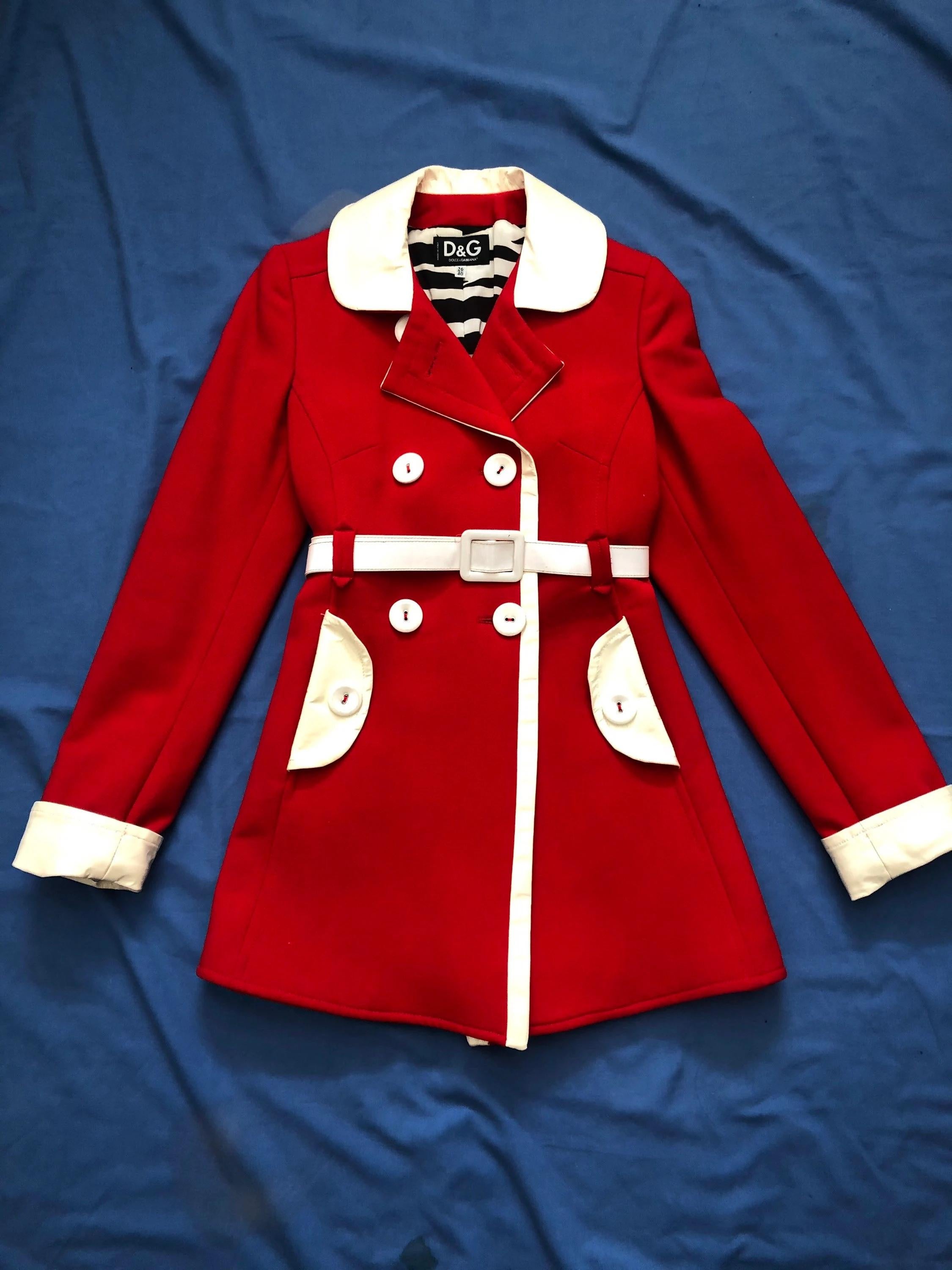 Laissez-vous séduire par la sophistication intemporelle de ce manteau rétro rouge à taille haute avec ceinture en cuir verni blanc de Dolce Gabbana des années 1990, issu de leurs incroyables collections Runway des années 1990. Ornée d'élégants