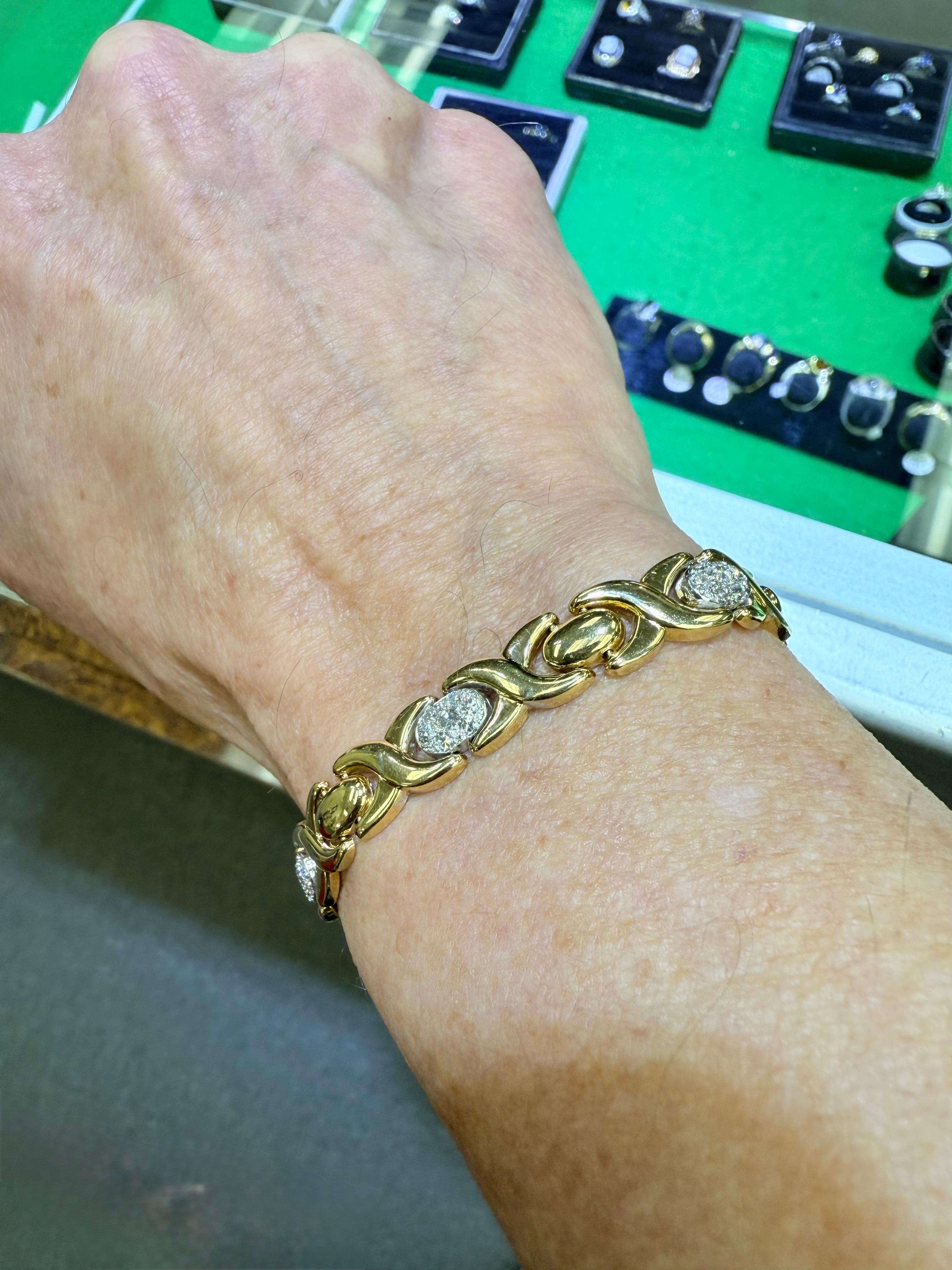 Bracelet en or bicolore 14k des années 1990, orné de diamants.
Le bracelet en or 14k à deux tons de diamants a été fabriqué dans les années 1990.  Des sections ovales de diamants pavés sont placées à côté de sections X plus larges en alternance. 