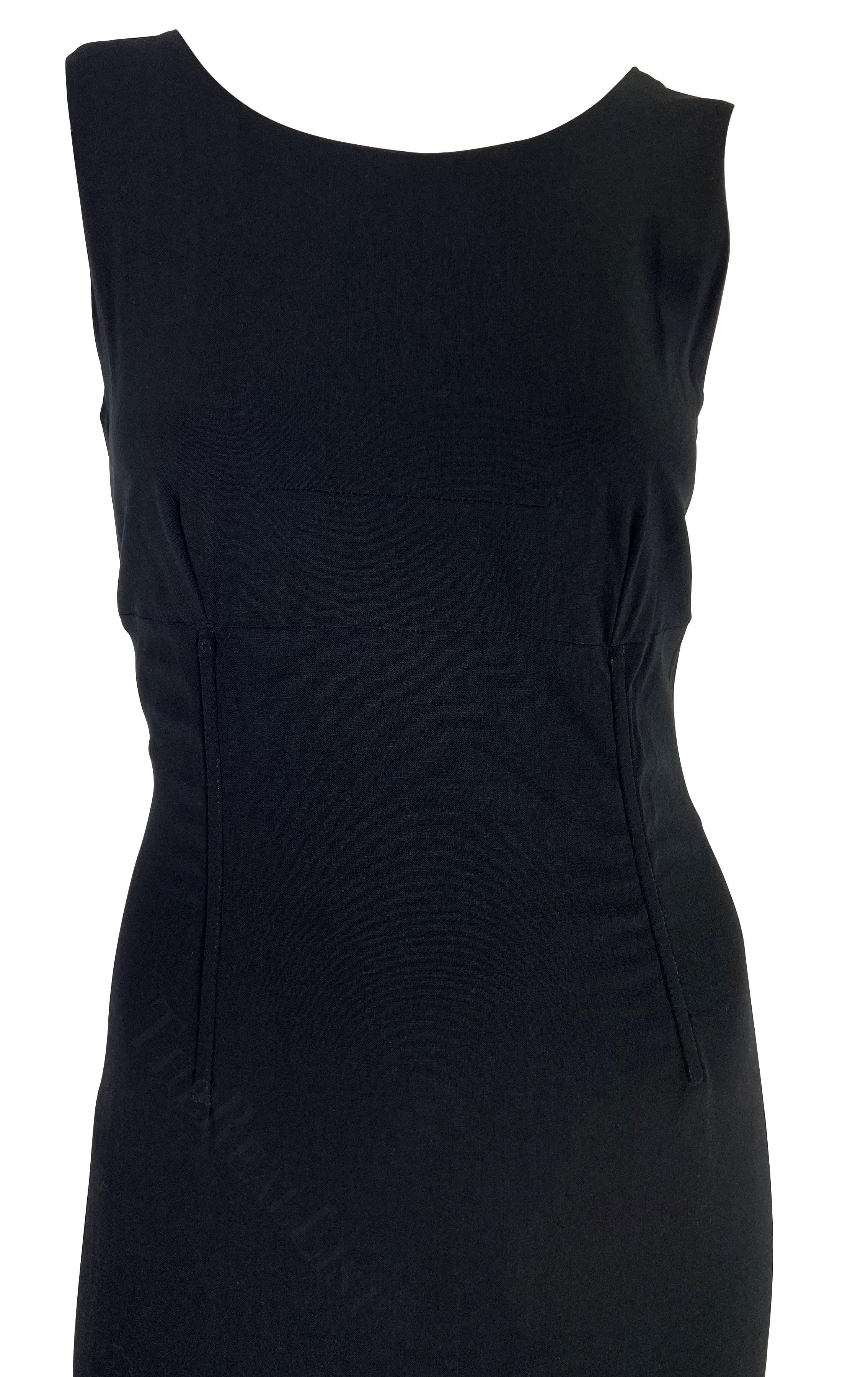 Présentation d'une magnifique robe midi noire Dolce and Gabbana. Datant du milieu des années 1990, cette robe chic et sans effort présente un large décolleté, un dos semi-exposé et est complétée par un corset à la taille, ce qui lui confère une