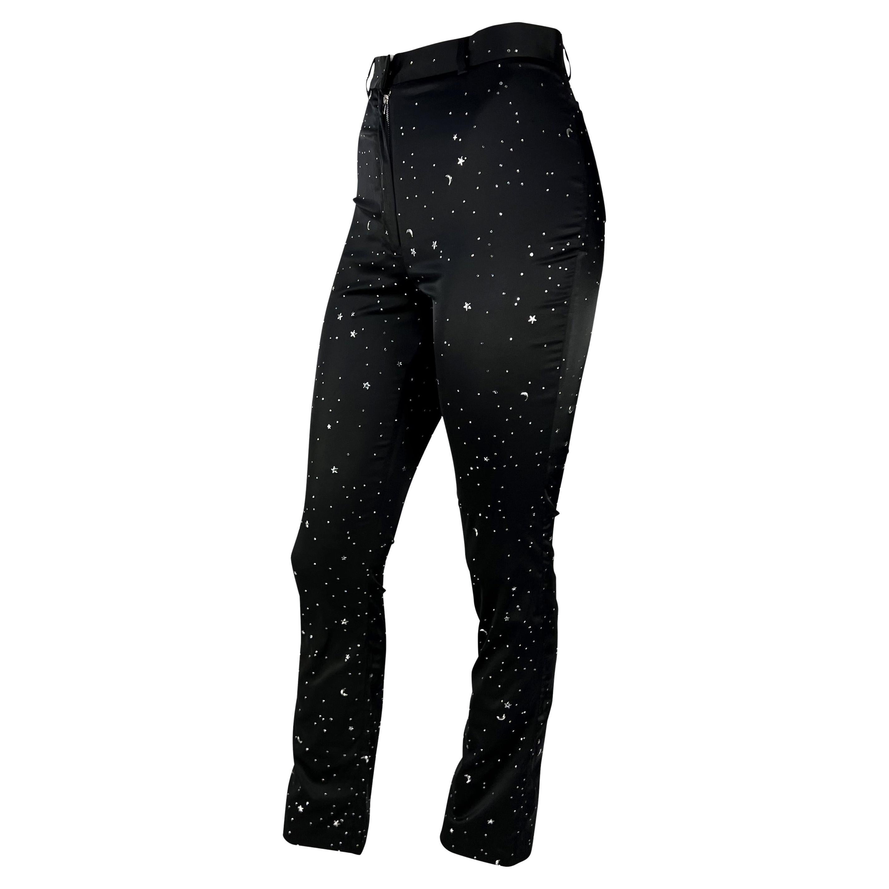 Presenting a pair of black satin stretch Dolce and Gabbana embellished constellation pants. From the 1990s, this fabulous pair of pants are constructed of soft shiny satin and are made complete with rhinestone and moon and star-shaped metal
