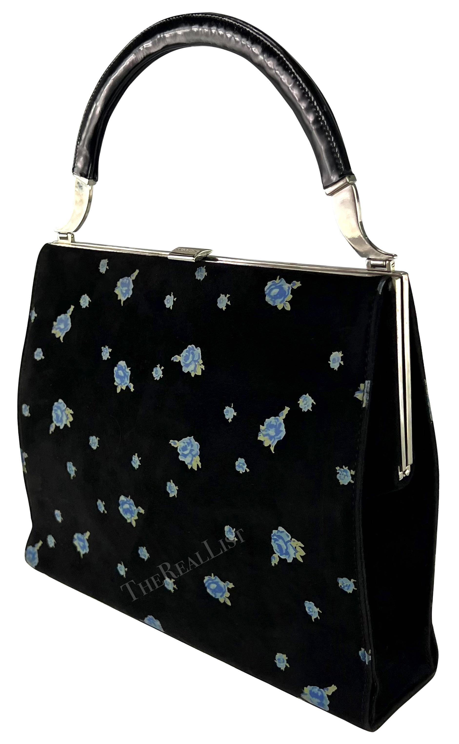 A fabulous black suede Dolce & Gabbana top handle bag from the 1990s. Crafted in suede, this bag showcases a striking blue rose print, The top handle is constructed of a glossy black handle and is made complete with silver-tone accents and a clam
